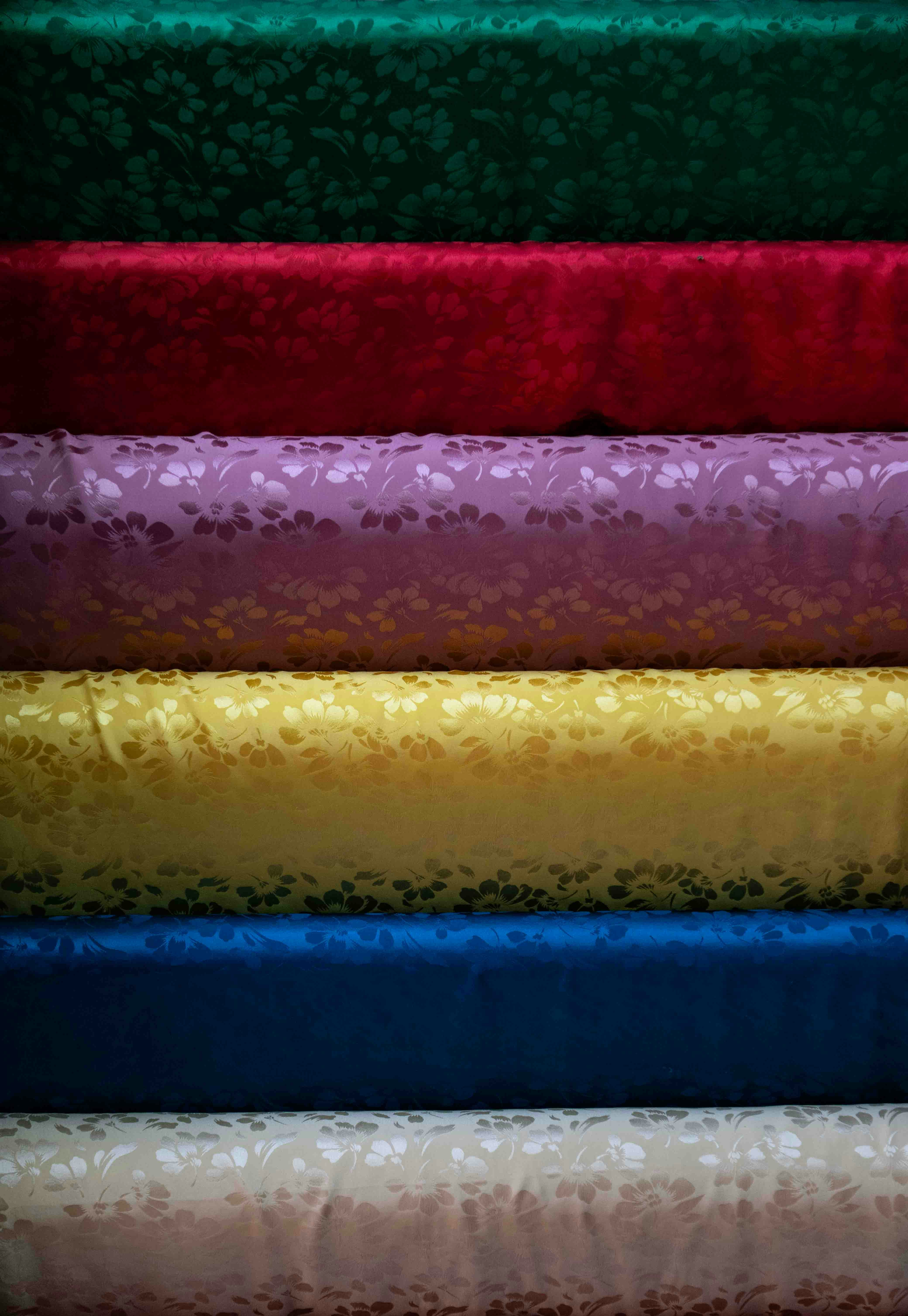 Stacked rolls of colorful patterned fabric