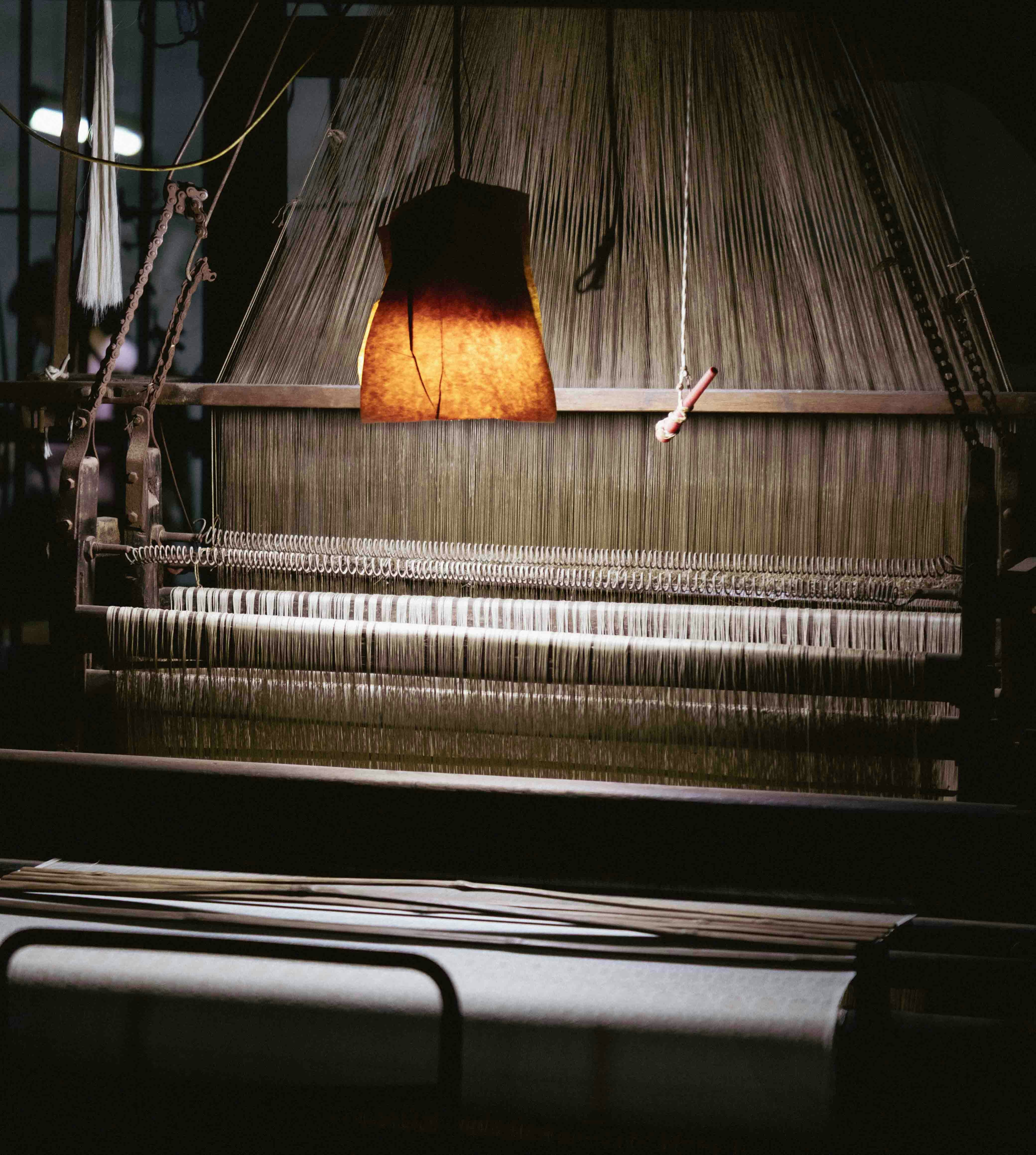 Antique loom with warm light illuminating threads
