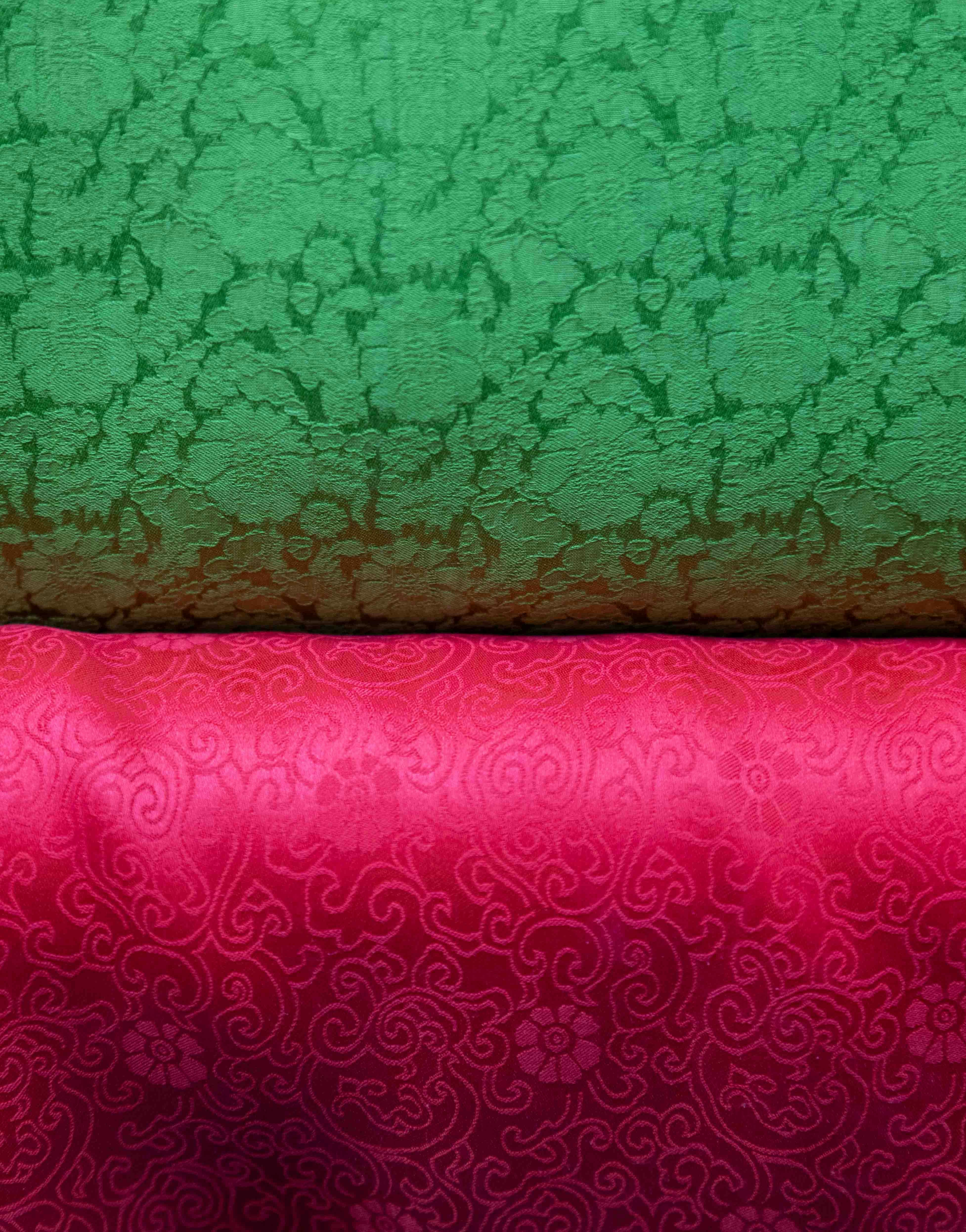 Two textured fabrics, green and pink, with floral patterns.