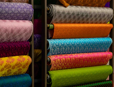 Stacks of colorful patterned fabric rolls on shelves
