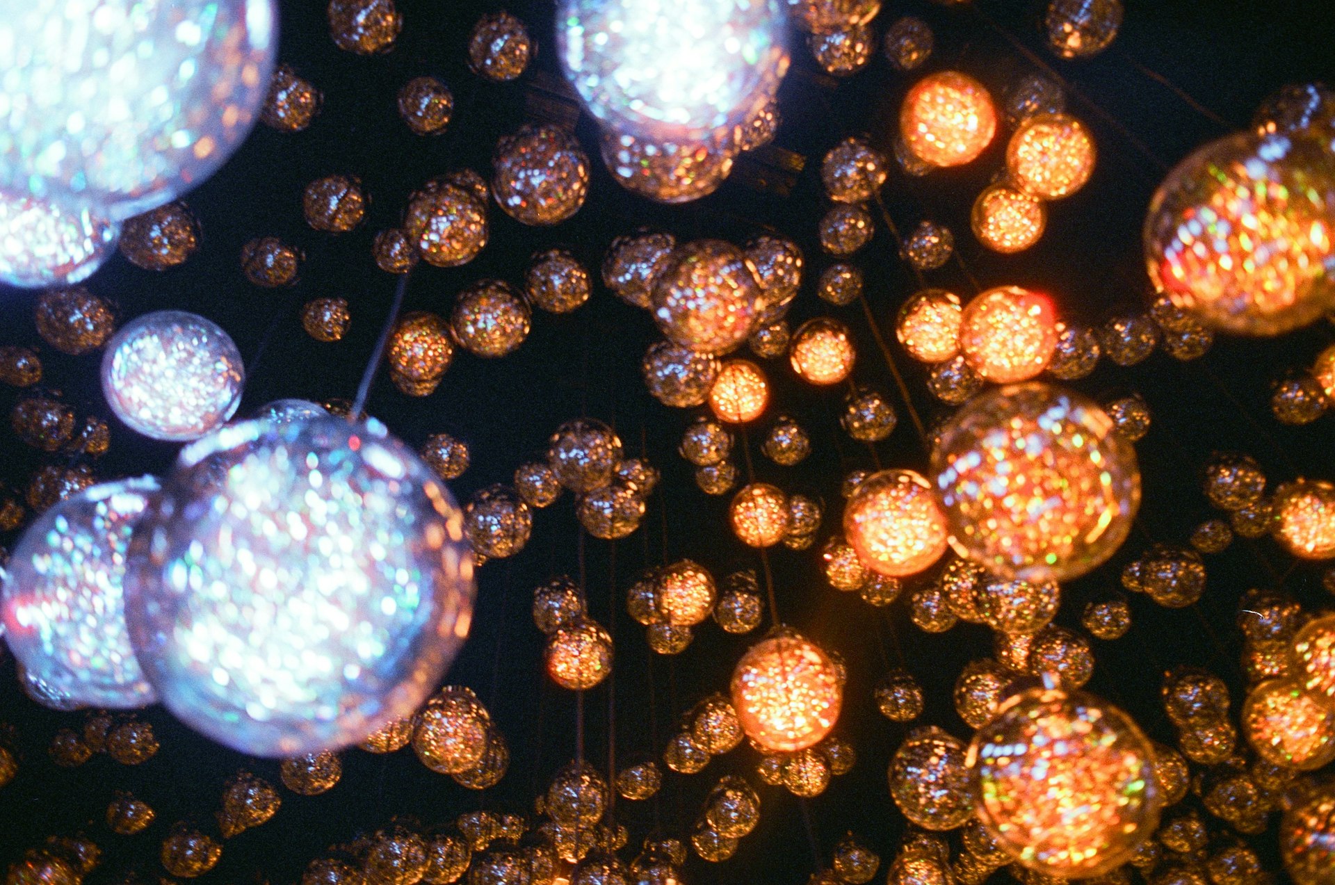 Numerous glowing spheres hang against a dark background.