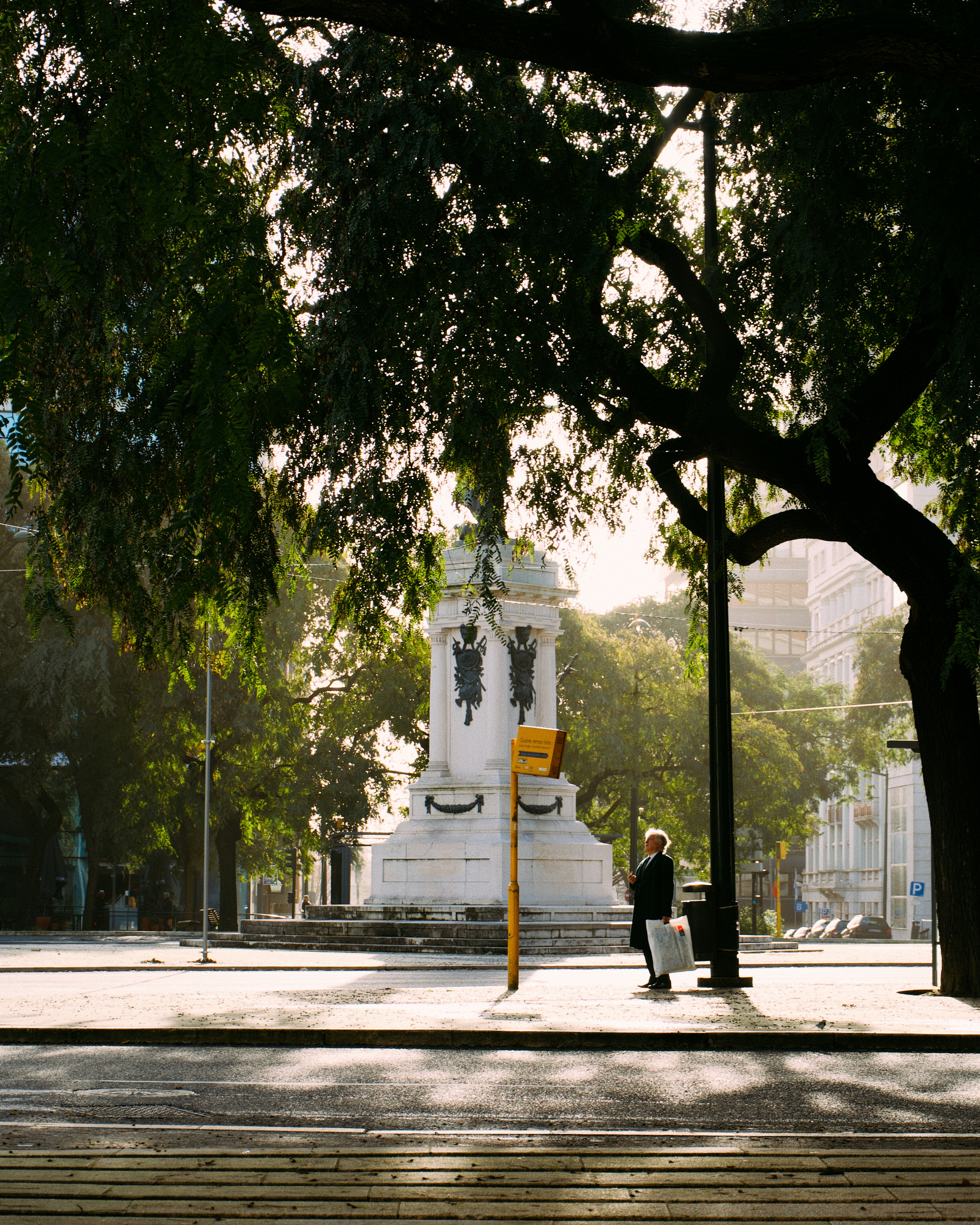 Une personne se tient près d’un monument par une journée ensoleillée.