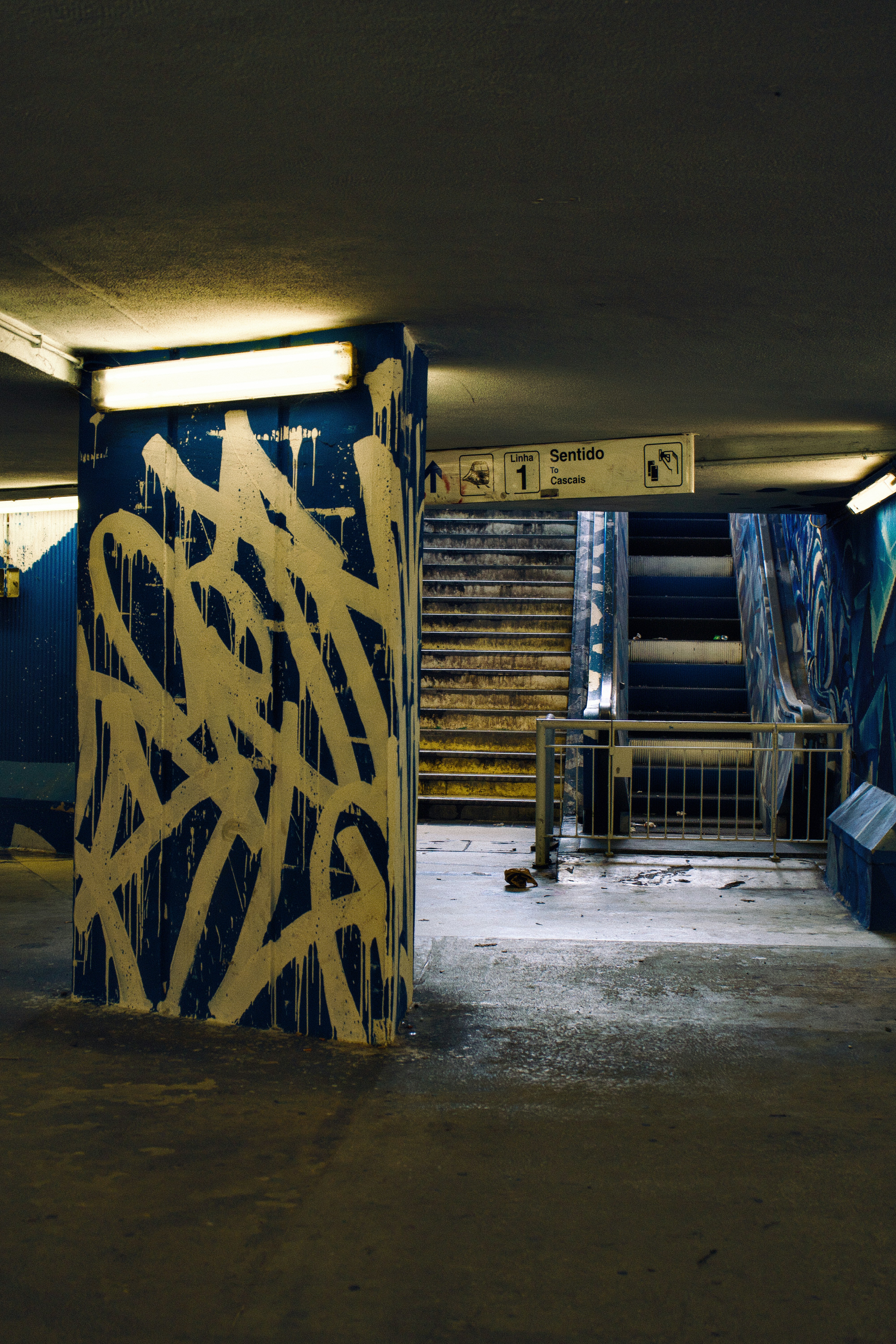 Pilier couvert de graffitis dans un passage souterrain faiblement éclairé
