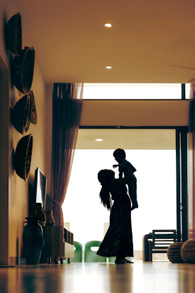Mother holding baby up in a modern home interior.