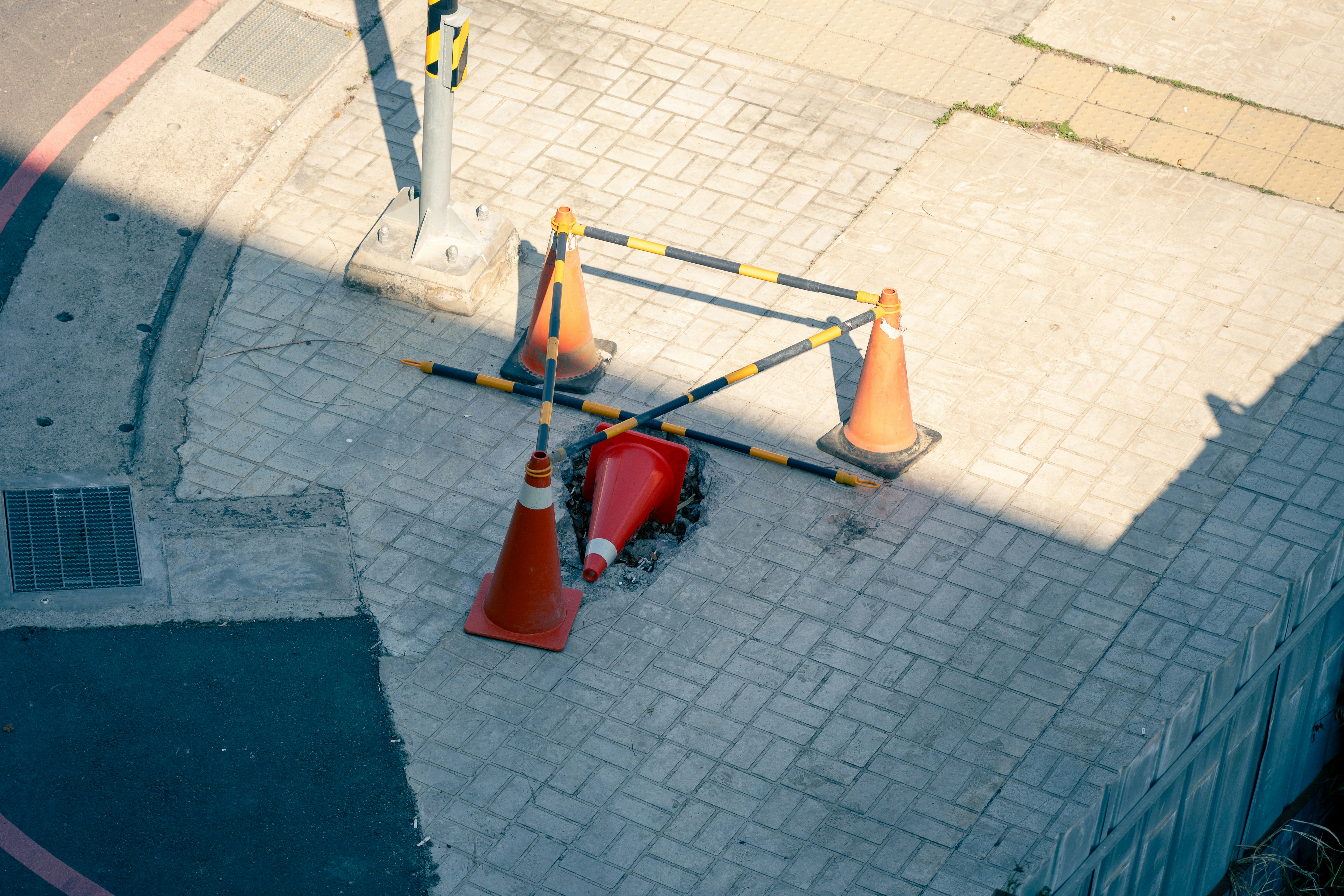 Orange traffic cones and barrier on sidewalk
