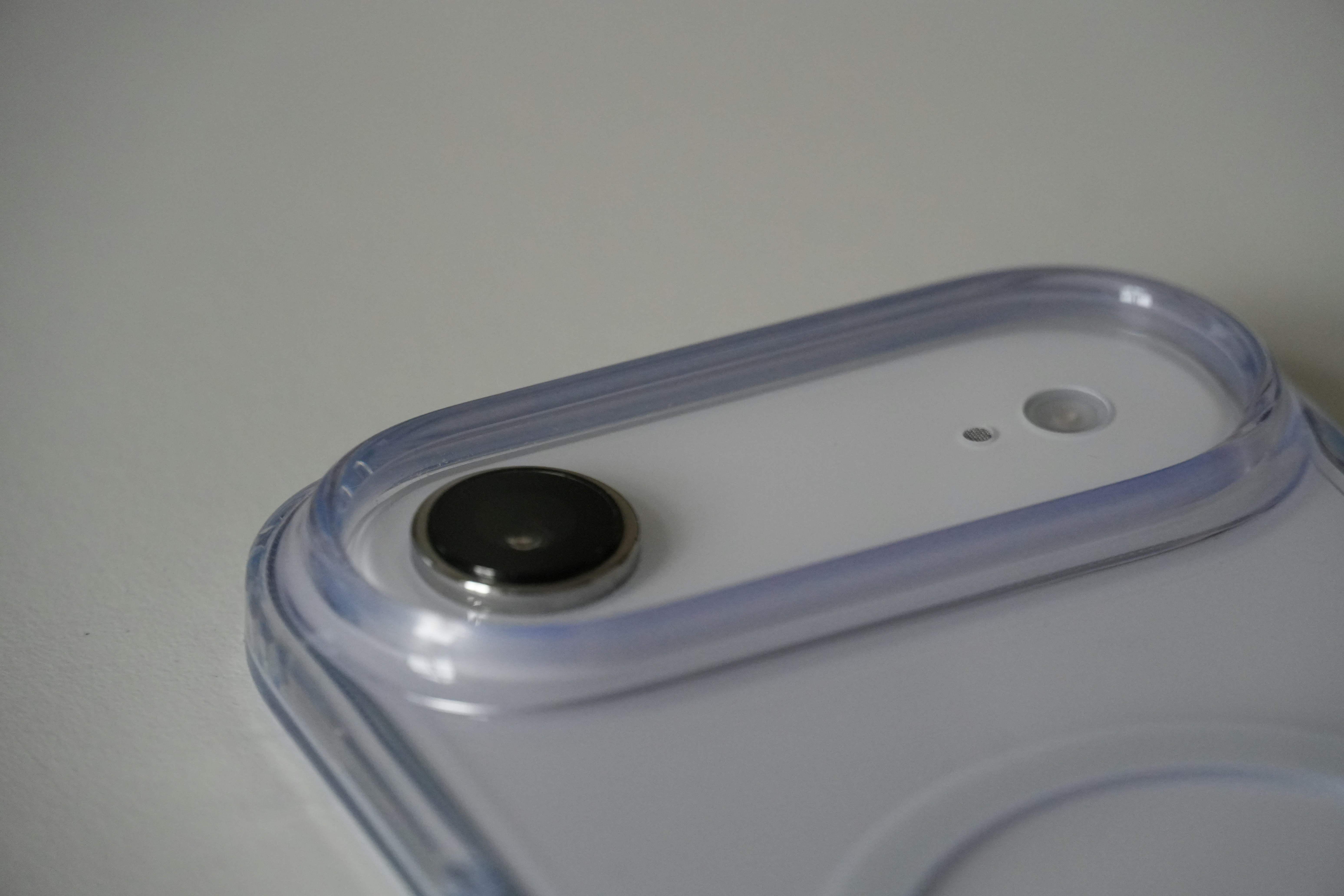 Close-up of a round button on a white surface.