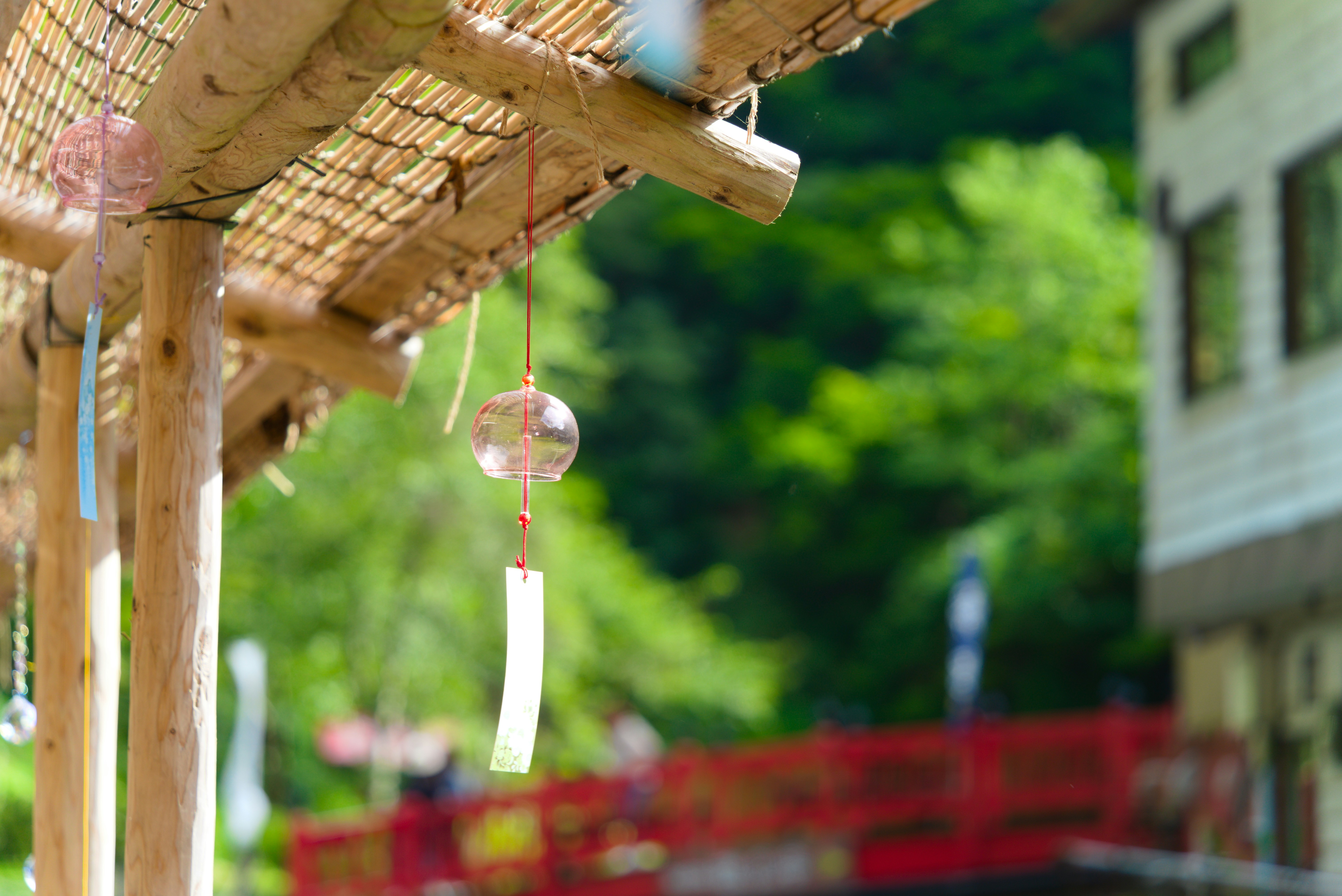Wind chimes hanging from a wooden porch roof