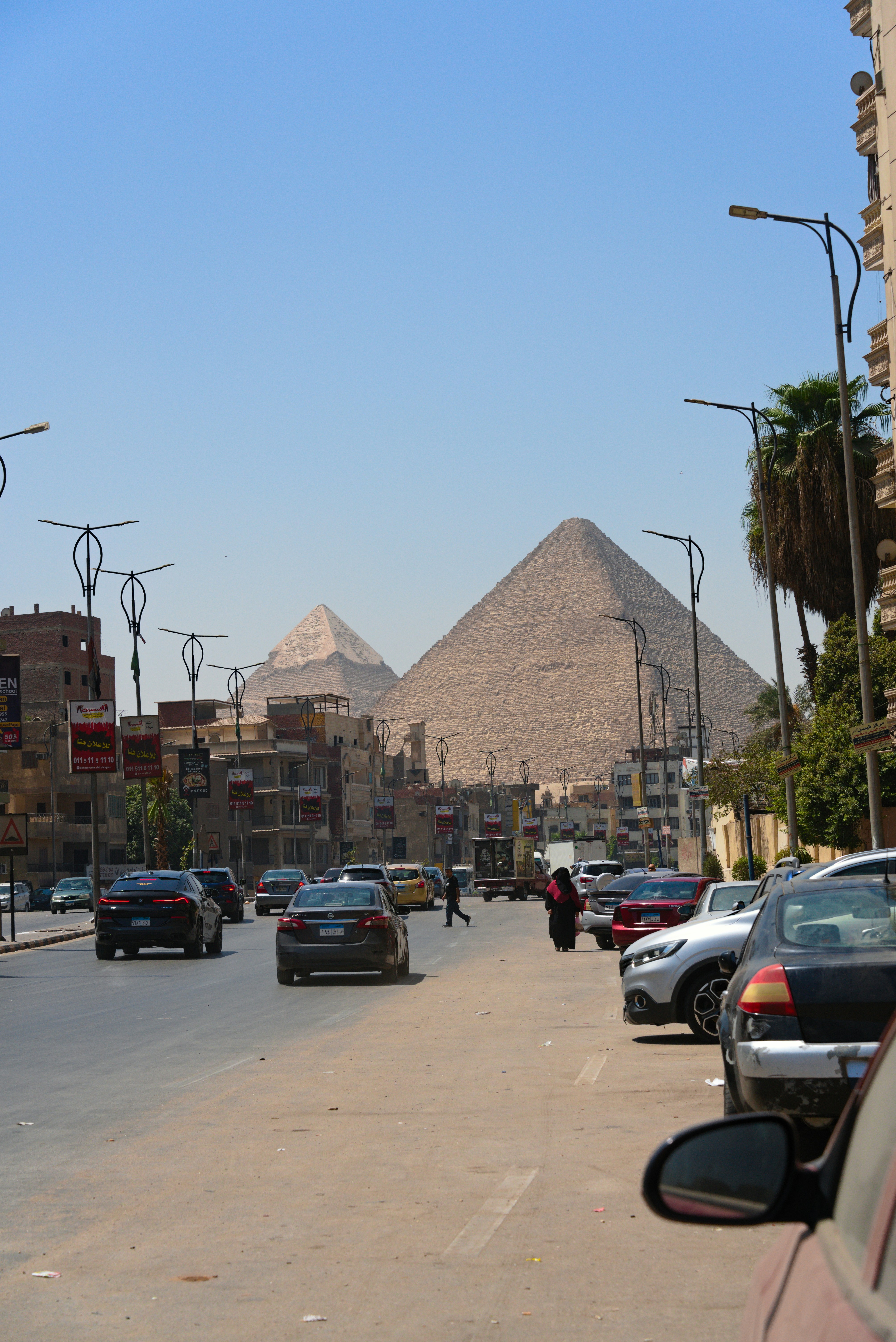 Pyramids visible behind a busy city street. photo – Free Cars Image on ...