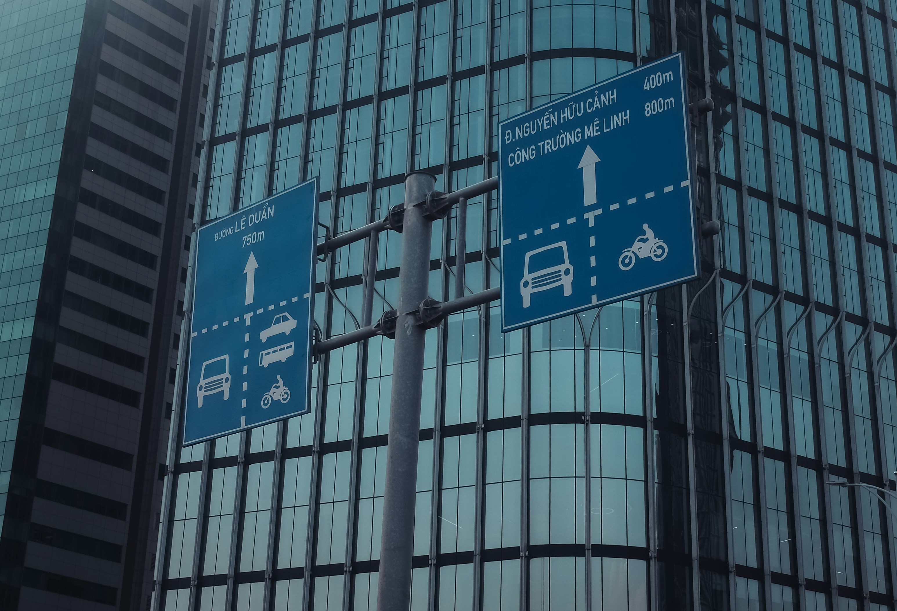 Street signs indicating directions for cars and motorcycles.