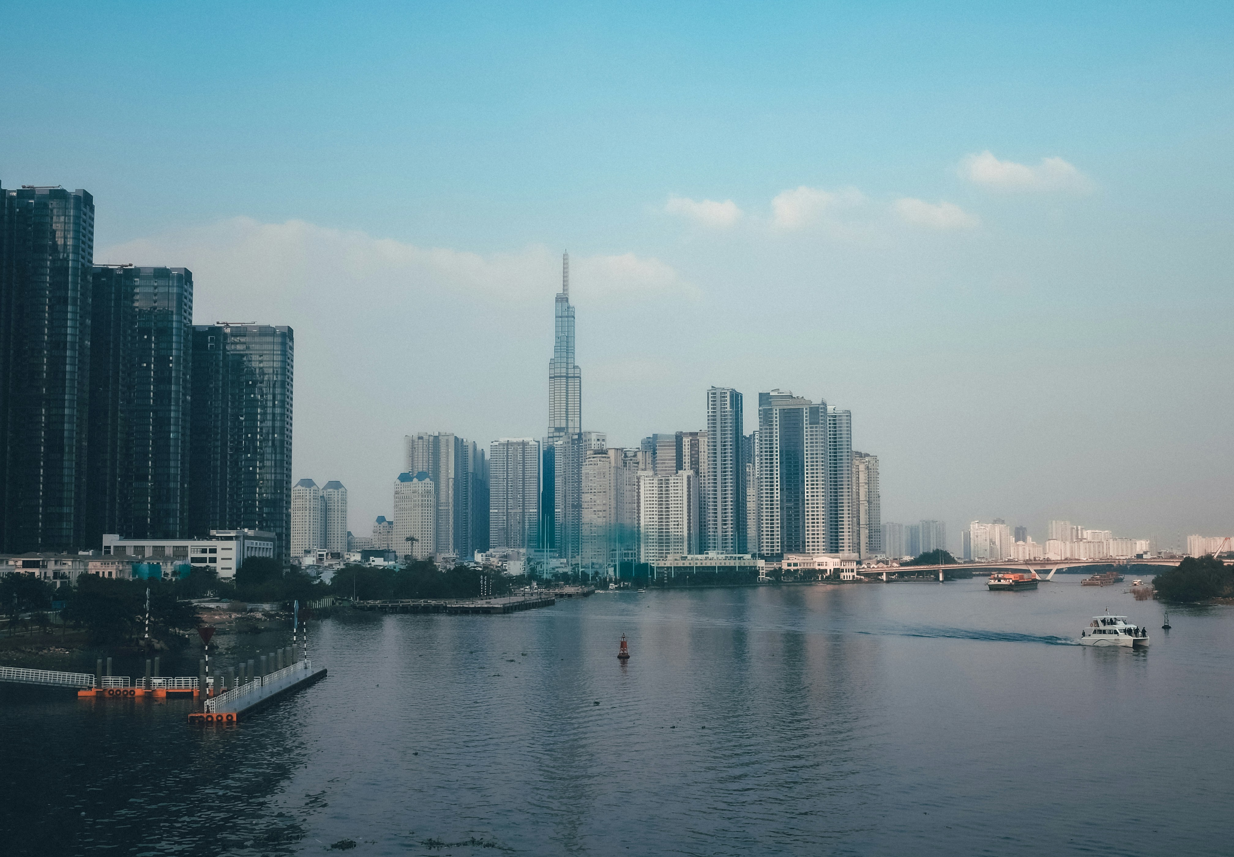 Modern cityscape with tall buildings along a river.