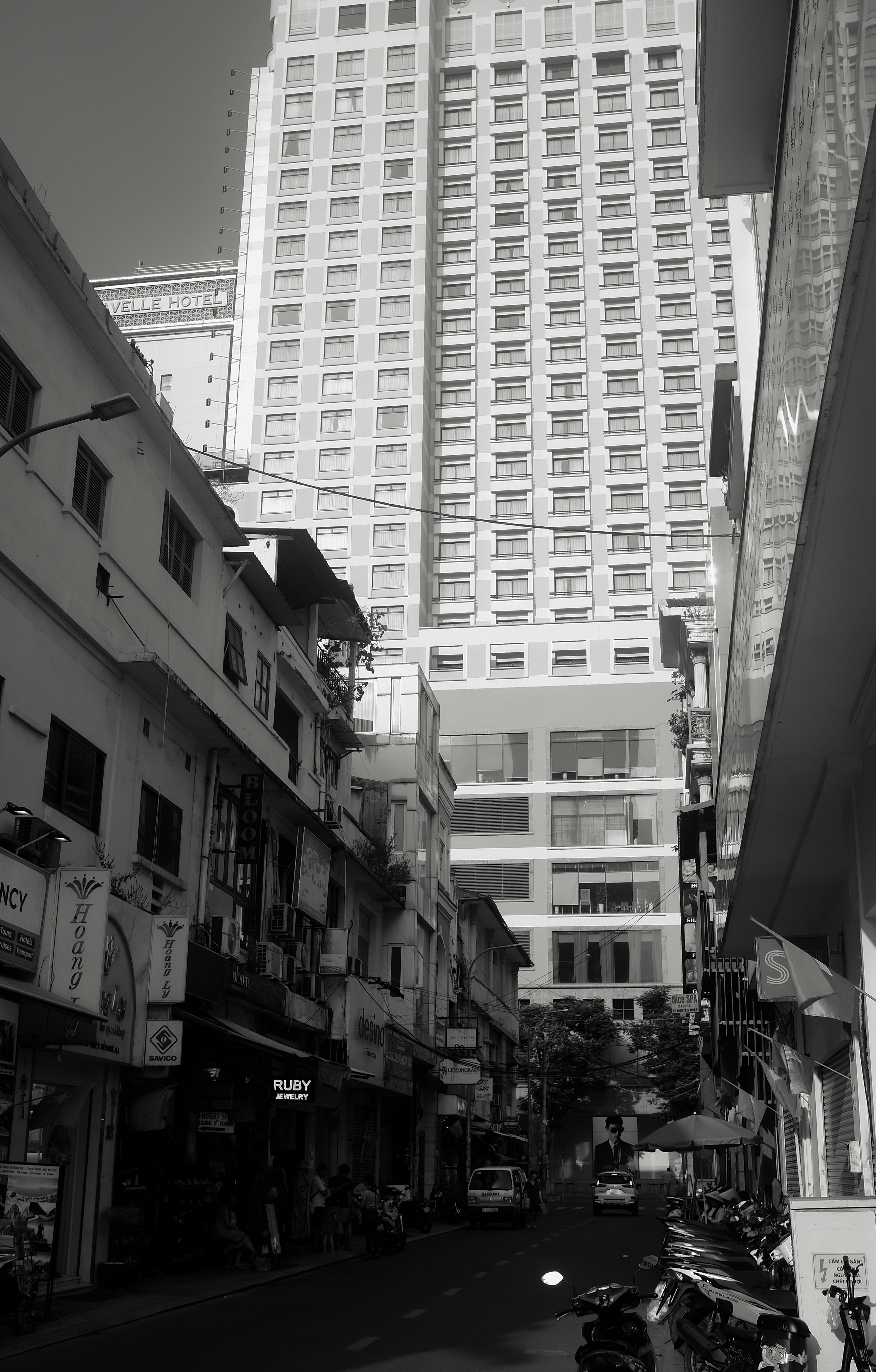 Narrow street with buildings and parked motorcycles.