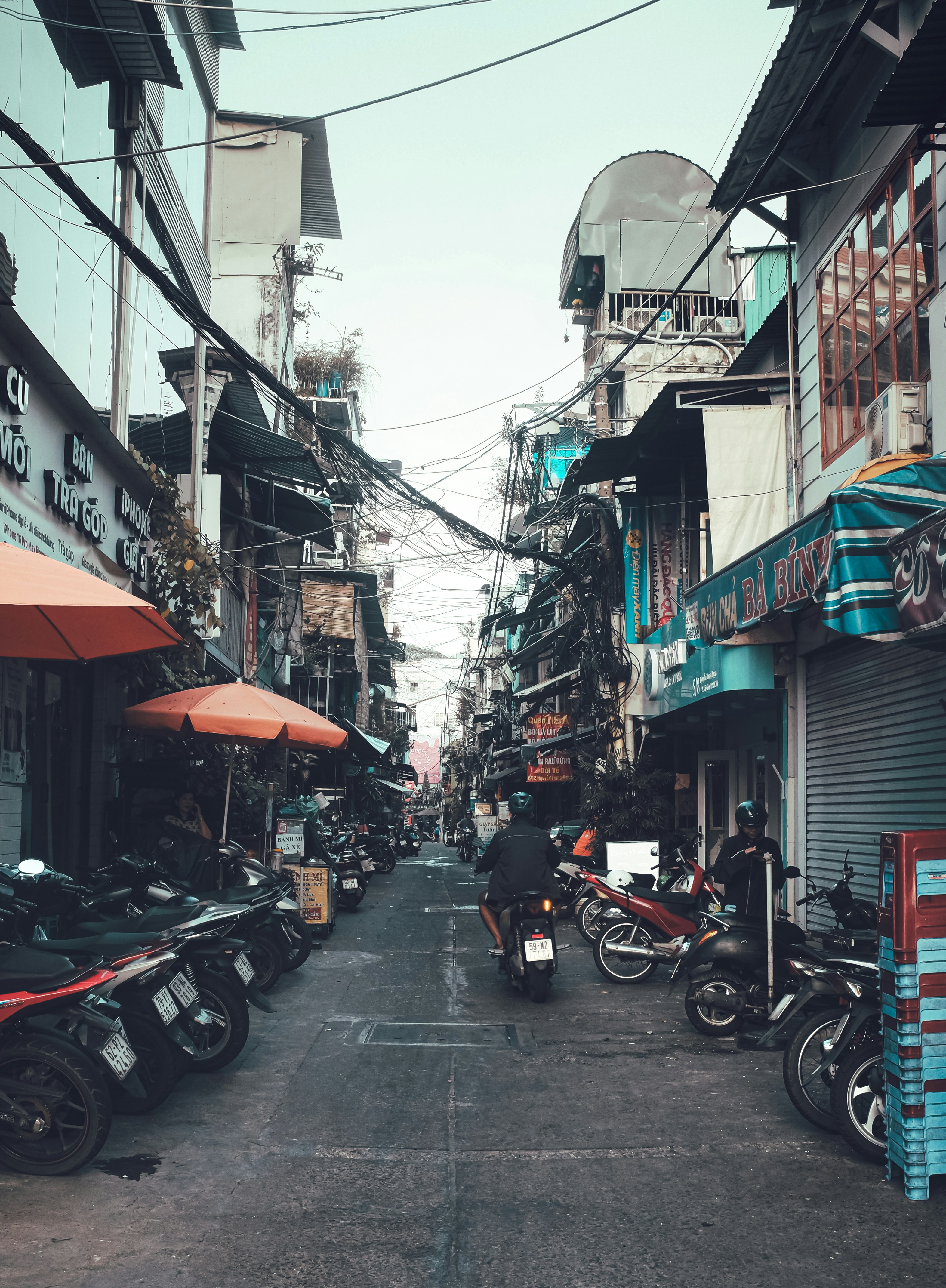 Motorcycles parked on a narrow street with buildings.