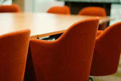 Orange chairs around a wooden conference table