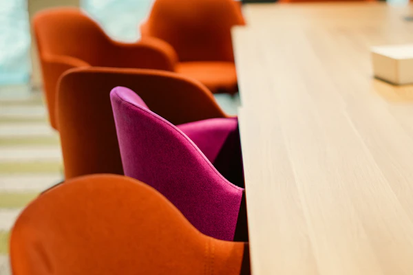 Miami corporate event venue - Orange and pink chairs at a wooden table.