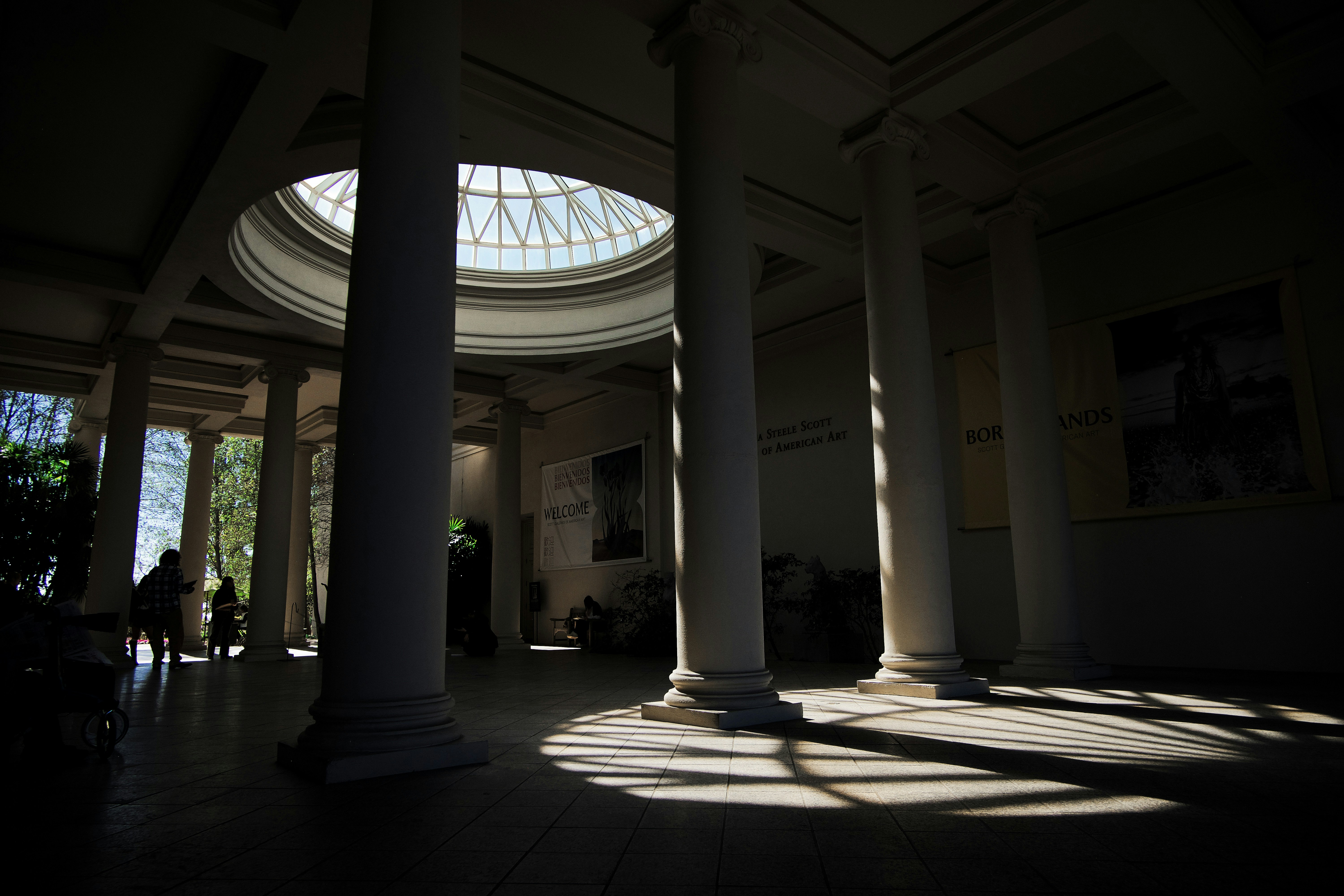 Sunlight streams through columns in a grand hall.