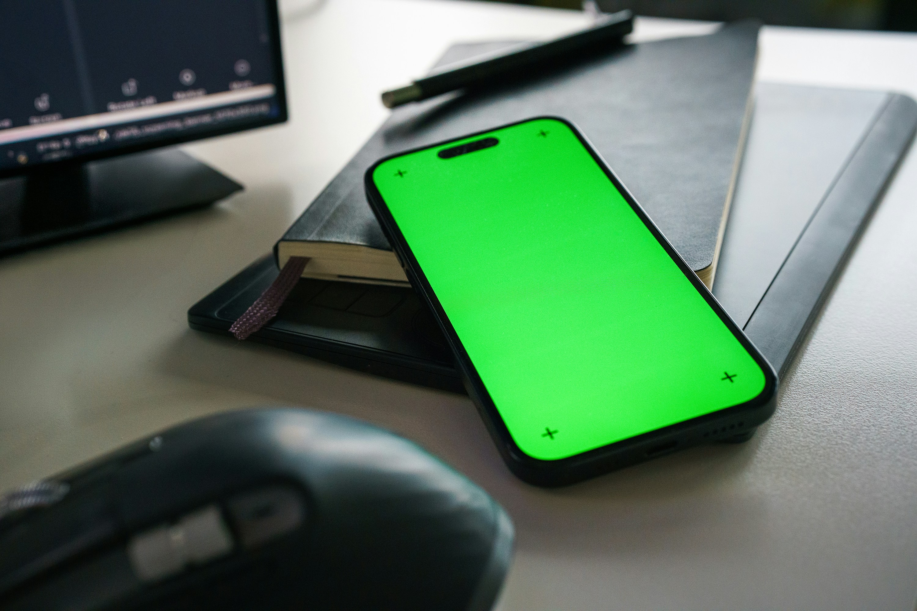 Smartphone with a green screen on a desk