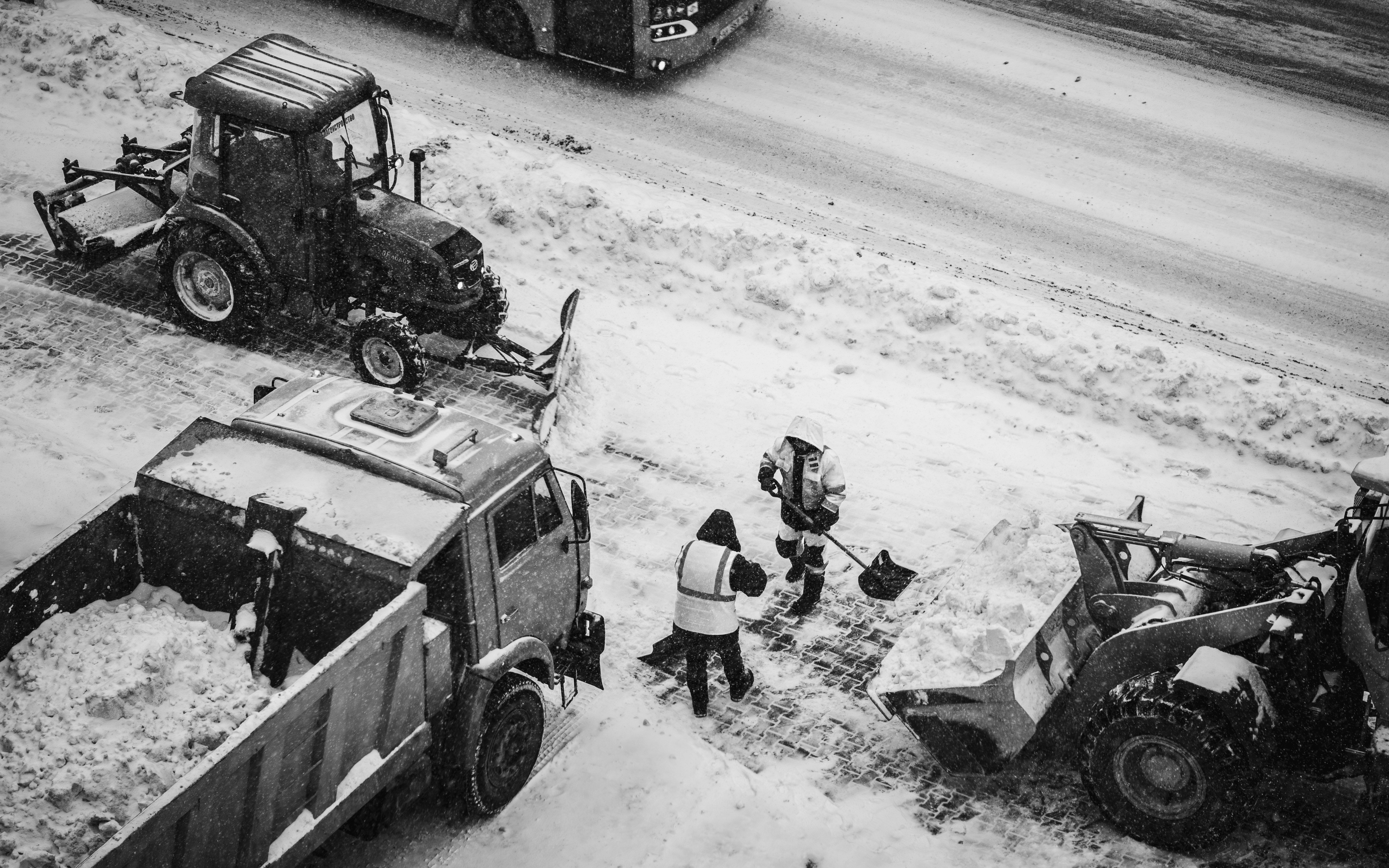 A city plow truck clearing a main Waltham artery during a winter storm - Waltham snow and ice management