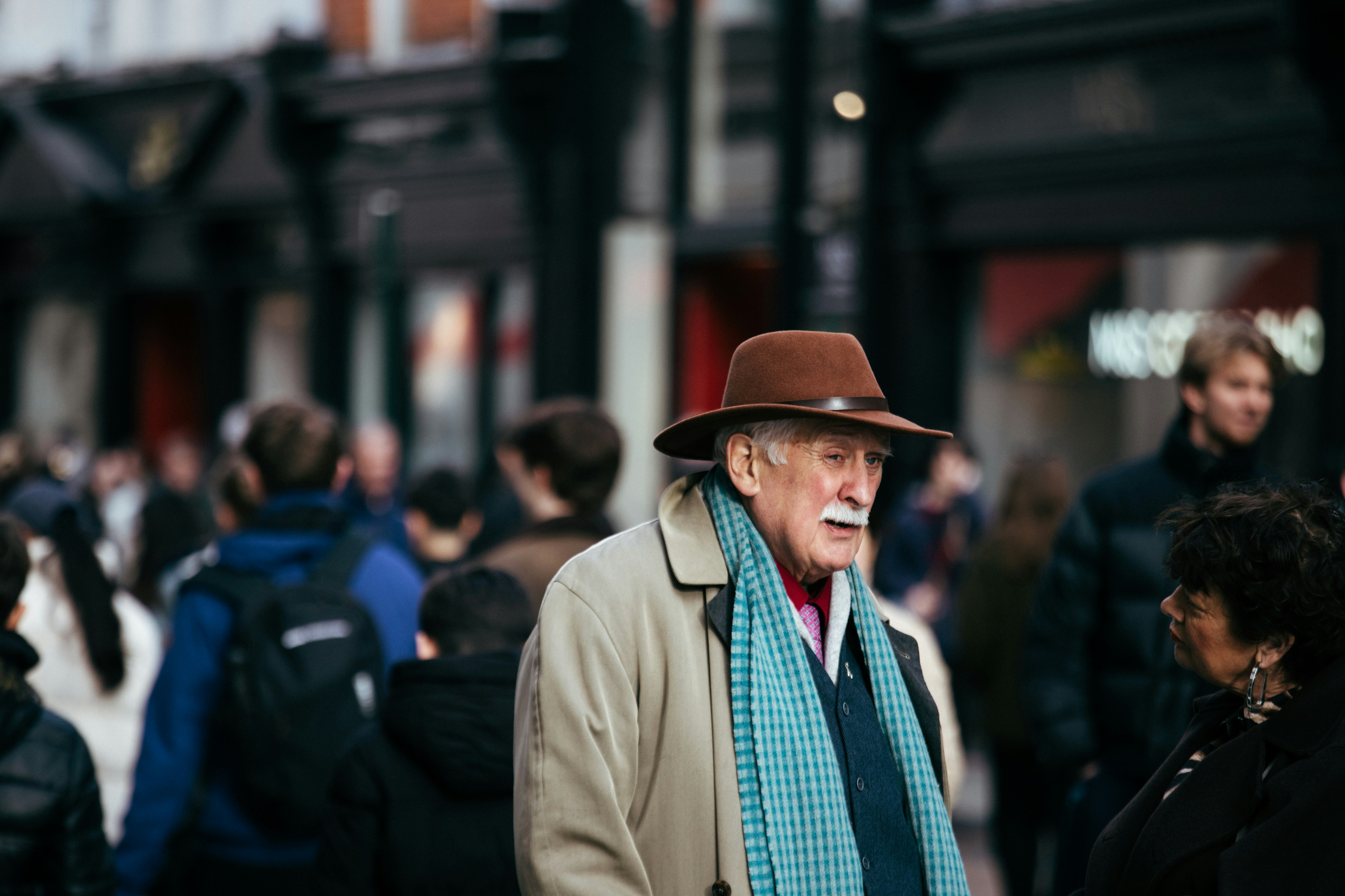 Elderly man in fedora hat on a busy street