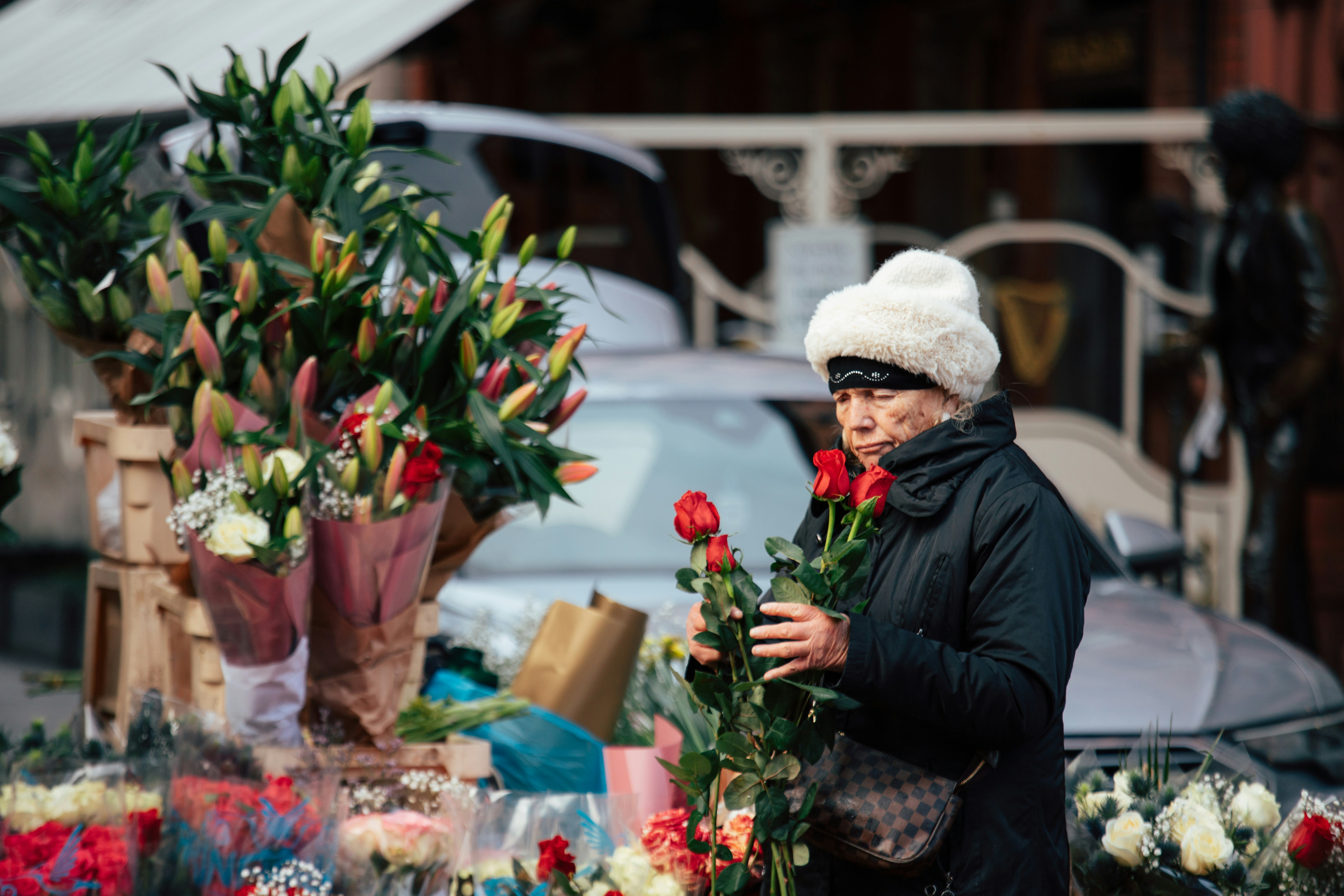 Woman choosing red roses at a flower stand.