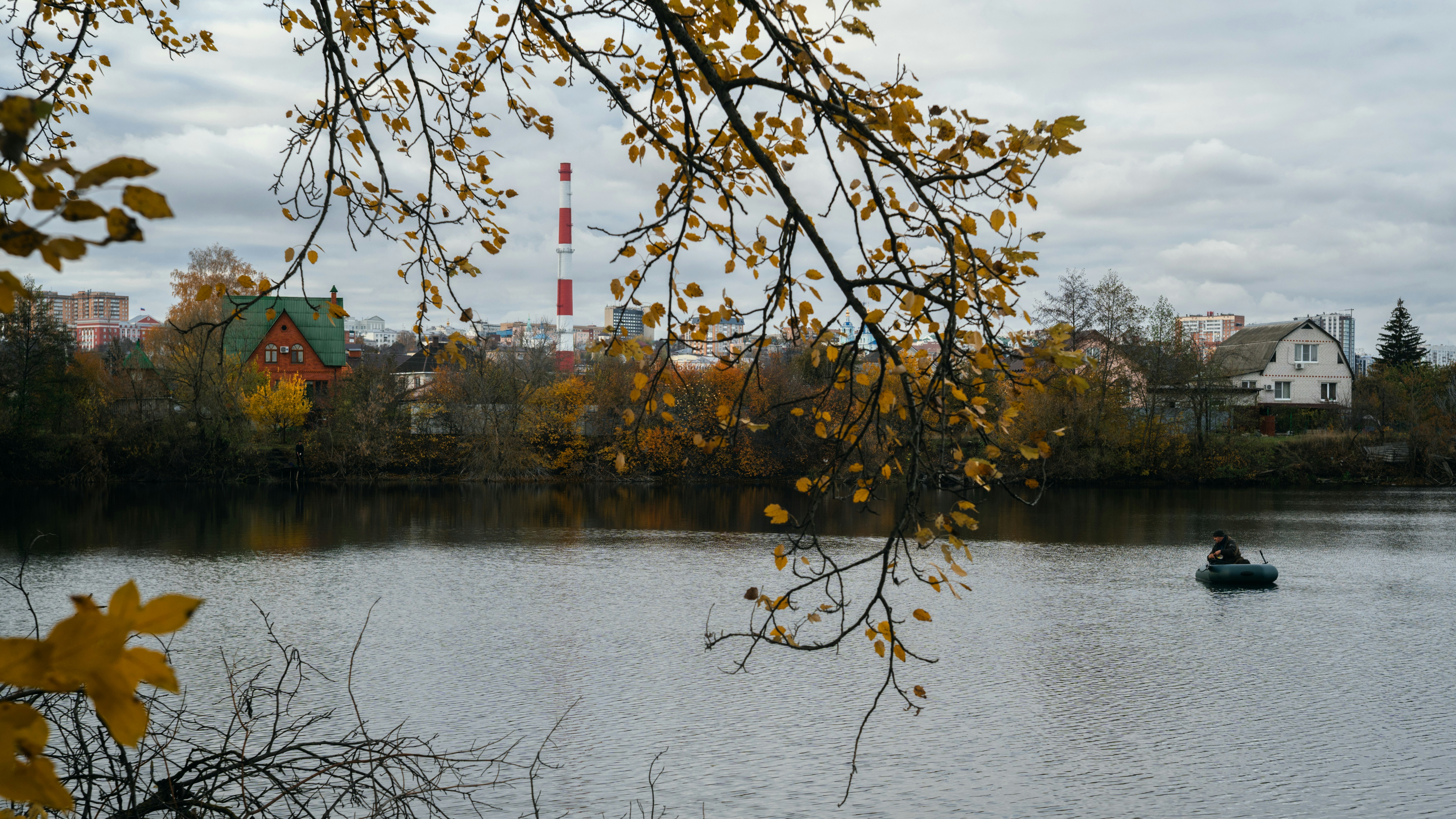 A lone figure in a small boat on a lake.