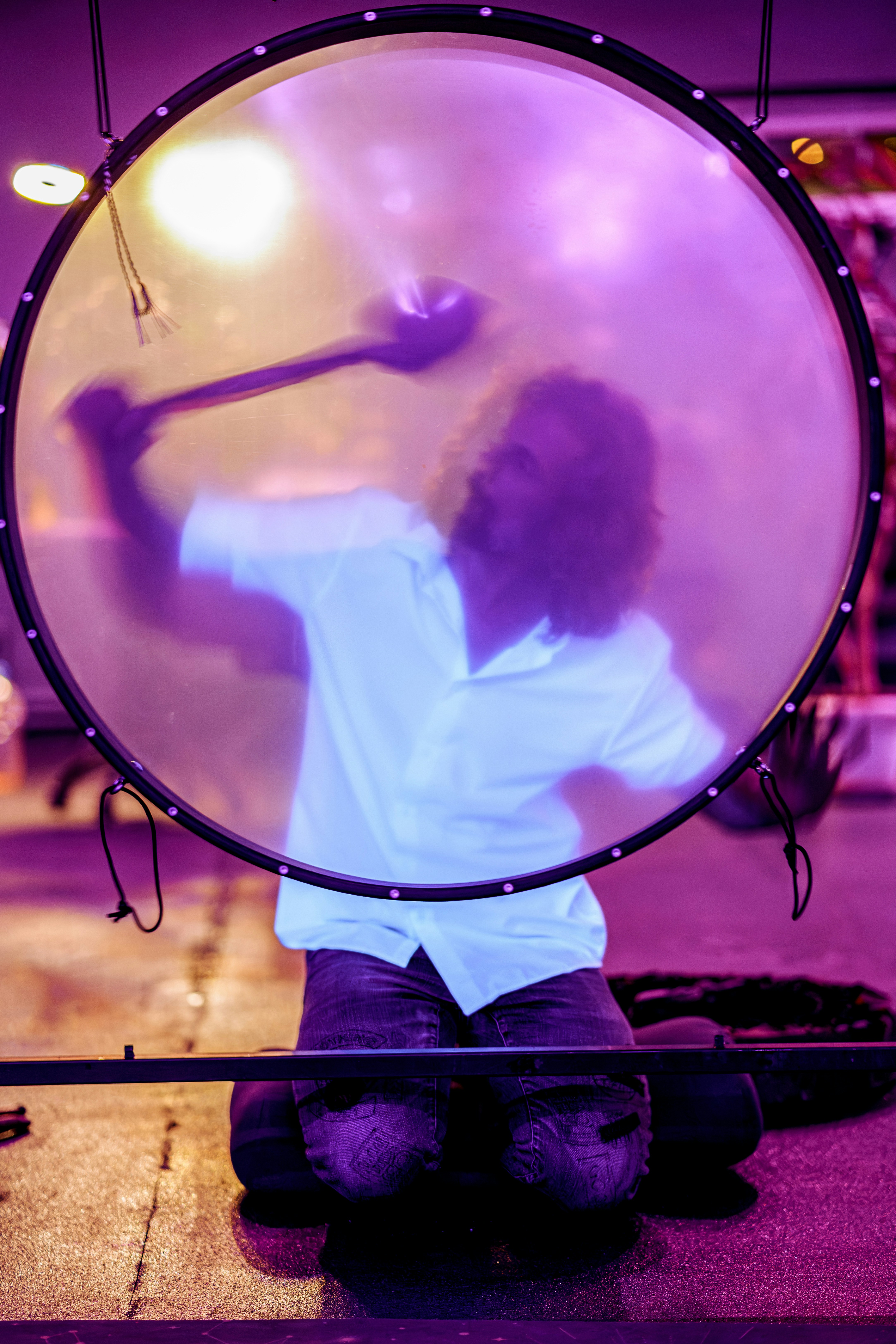 Man playing a large gong with a mallet