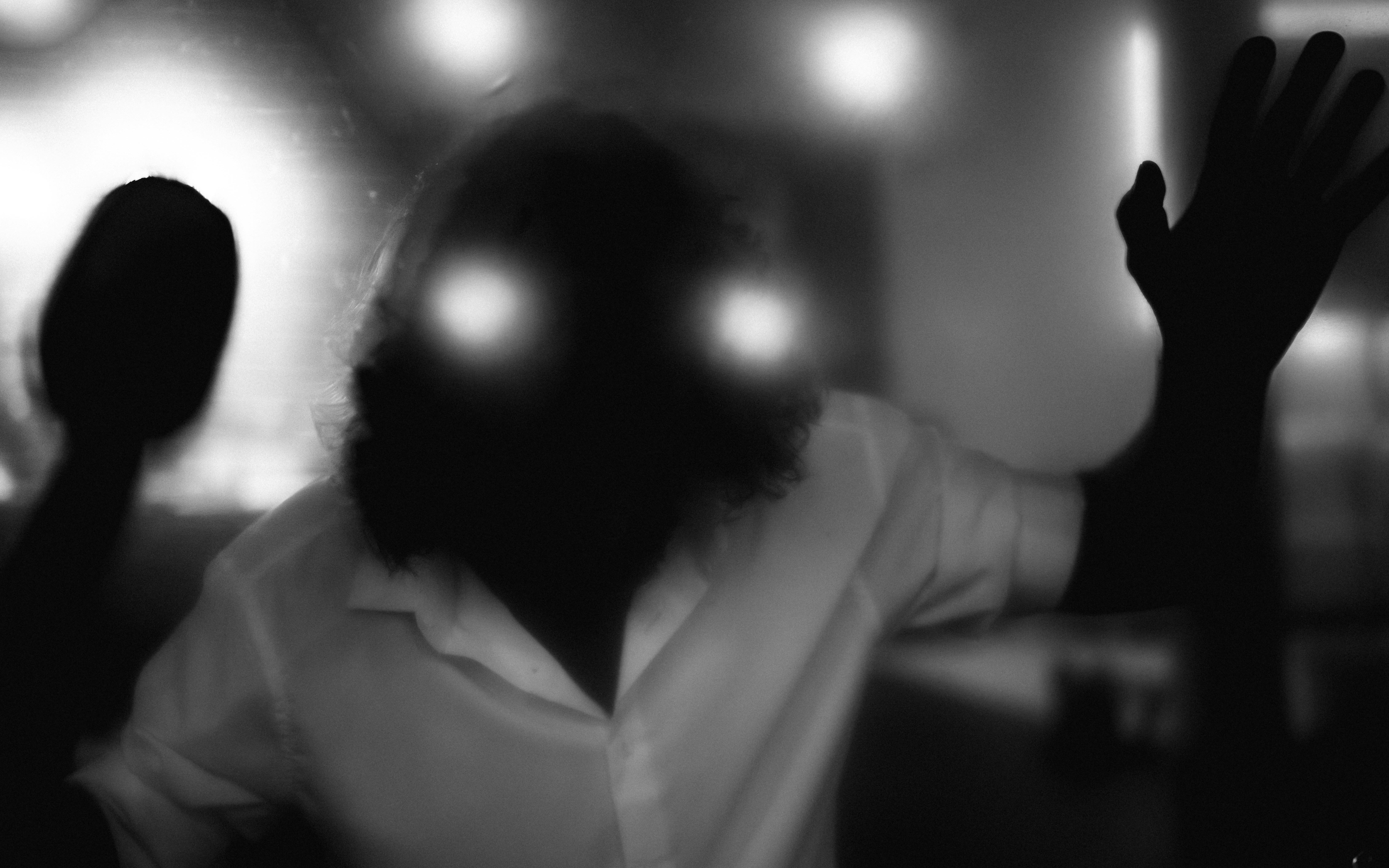 A person with glowing eyes and raised hands