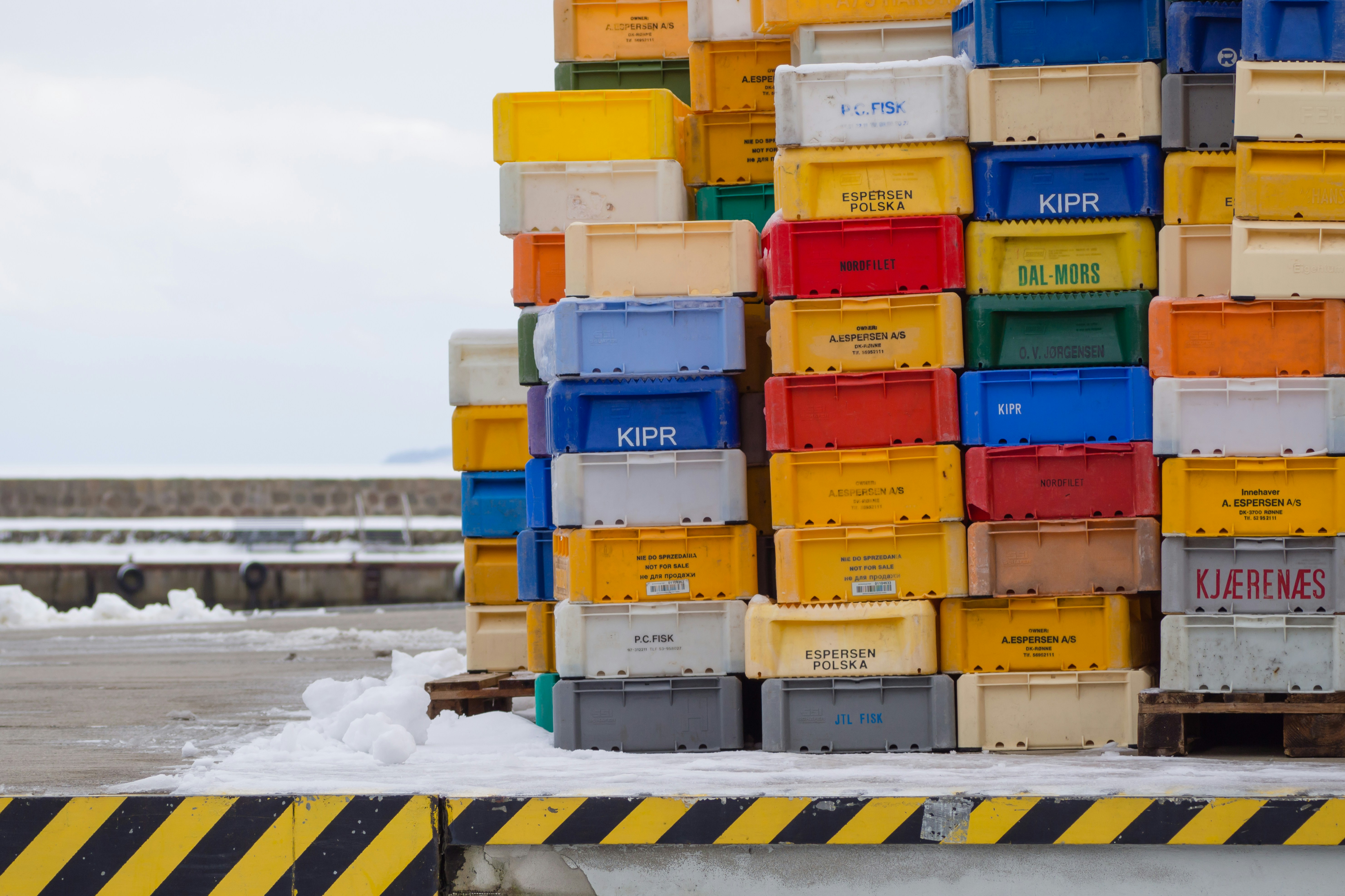 Stacked colorful plastic crates in a snowy outdoor area
