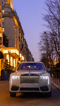 Luxury car parked on a street at dusk.