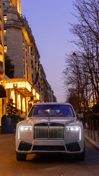 Luxury car parked on a street at dusk.