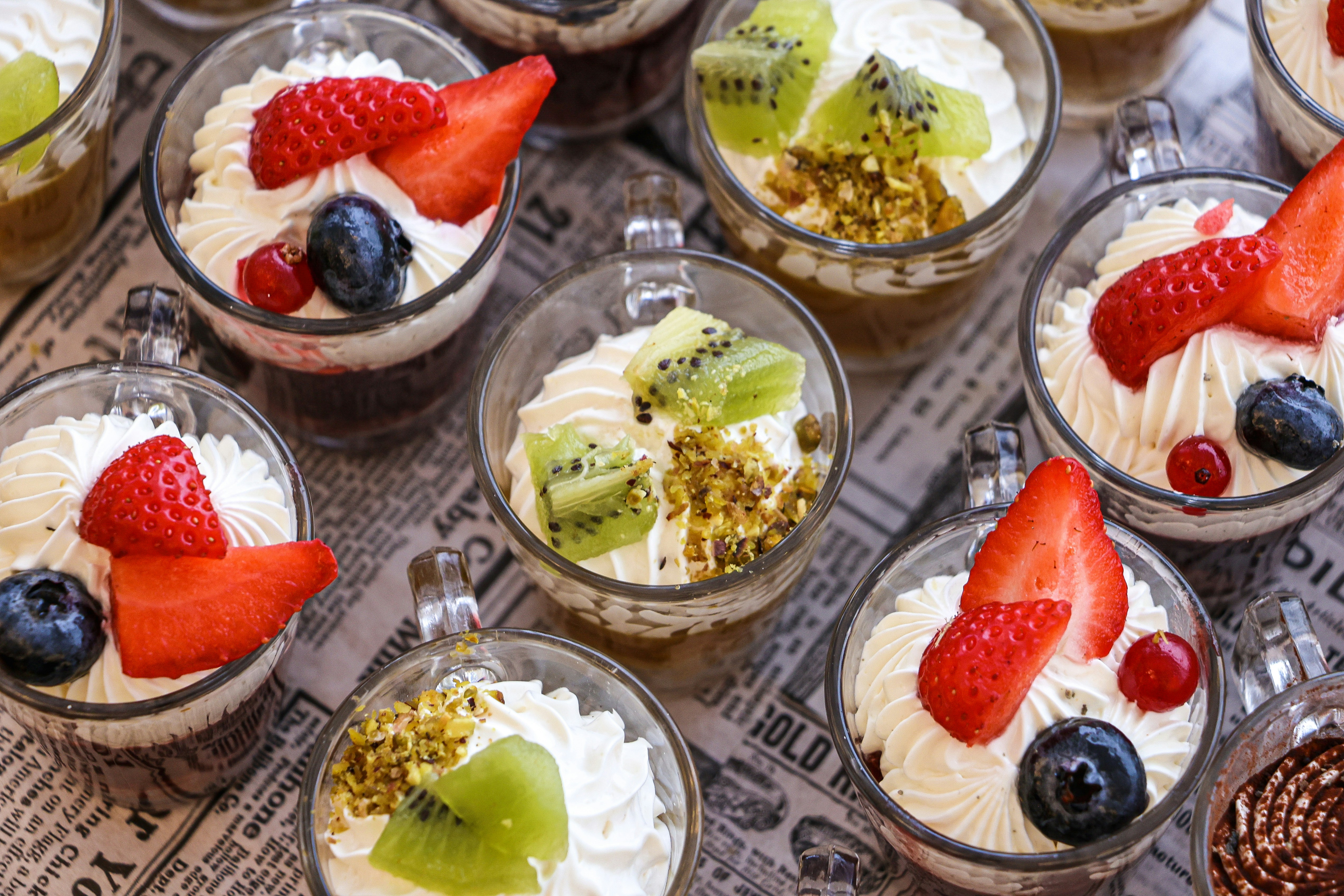 Sobremesas cobertas com chantilly, frutas e castanhas.