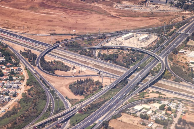 Aerial view of a multi-level freeway interchange with curving ramps, similar to the flyover being built at the 215 Beltway and Summerlin Parkway