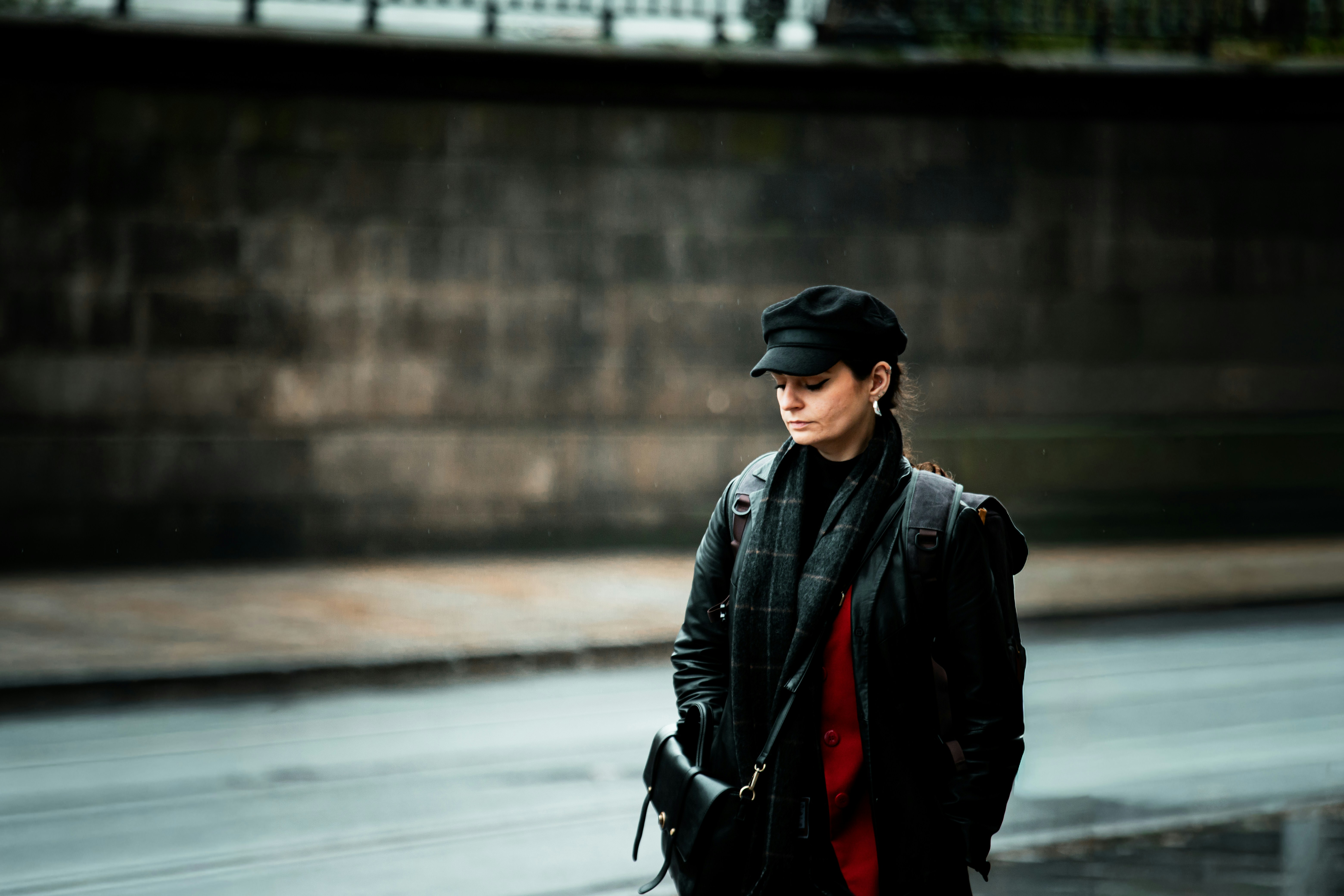 Woman in cap and scarf standing on street