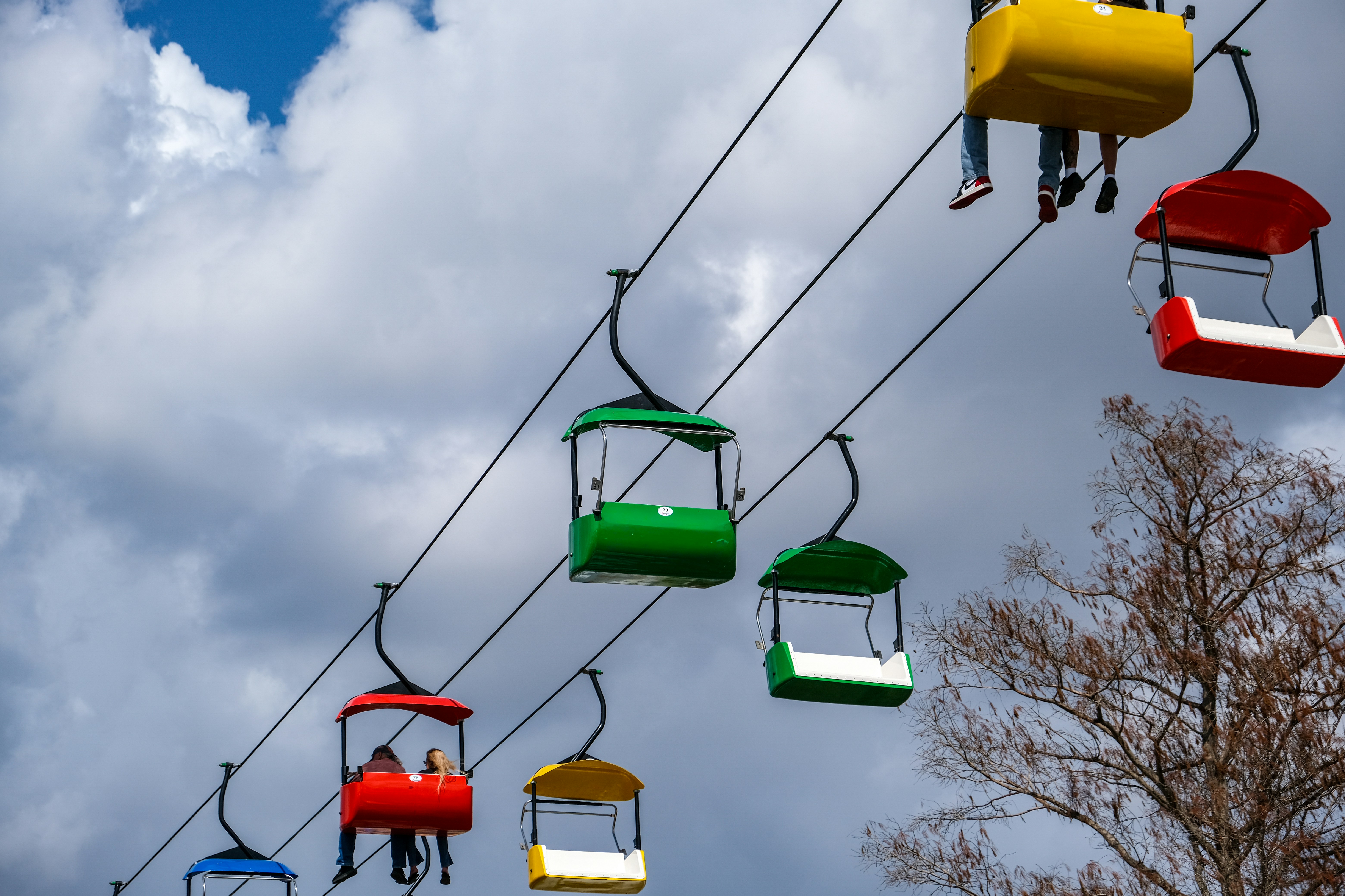 Colorful gondolas ascend a cloudy sky