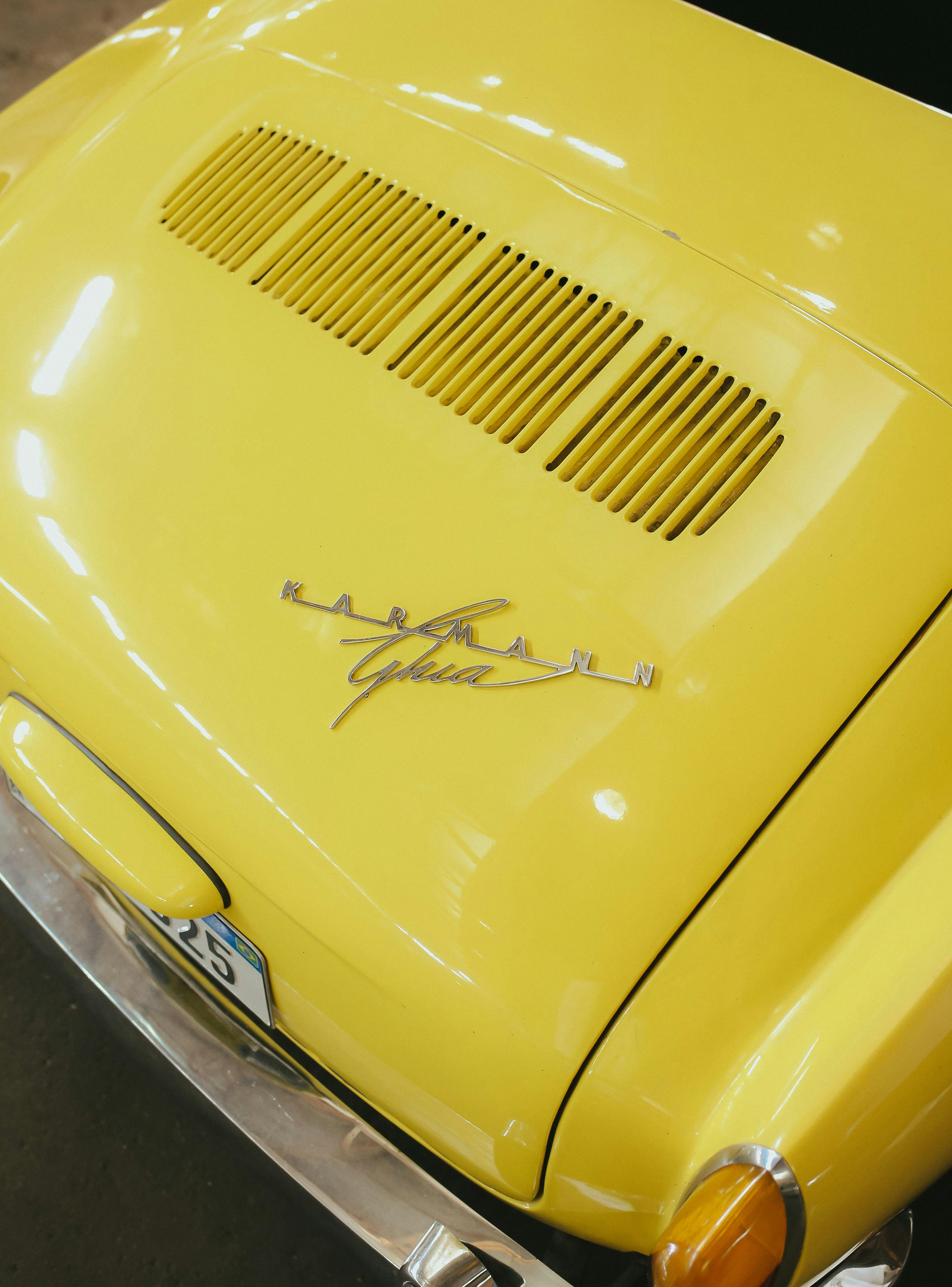 Close-up of a yellow vintage car's emblem.