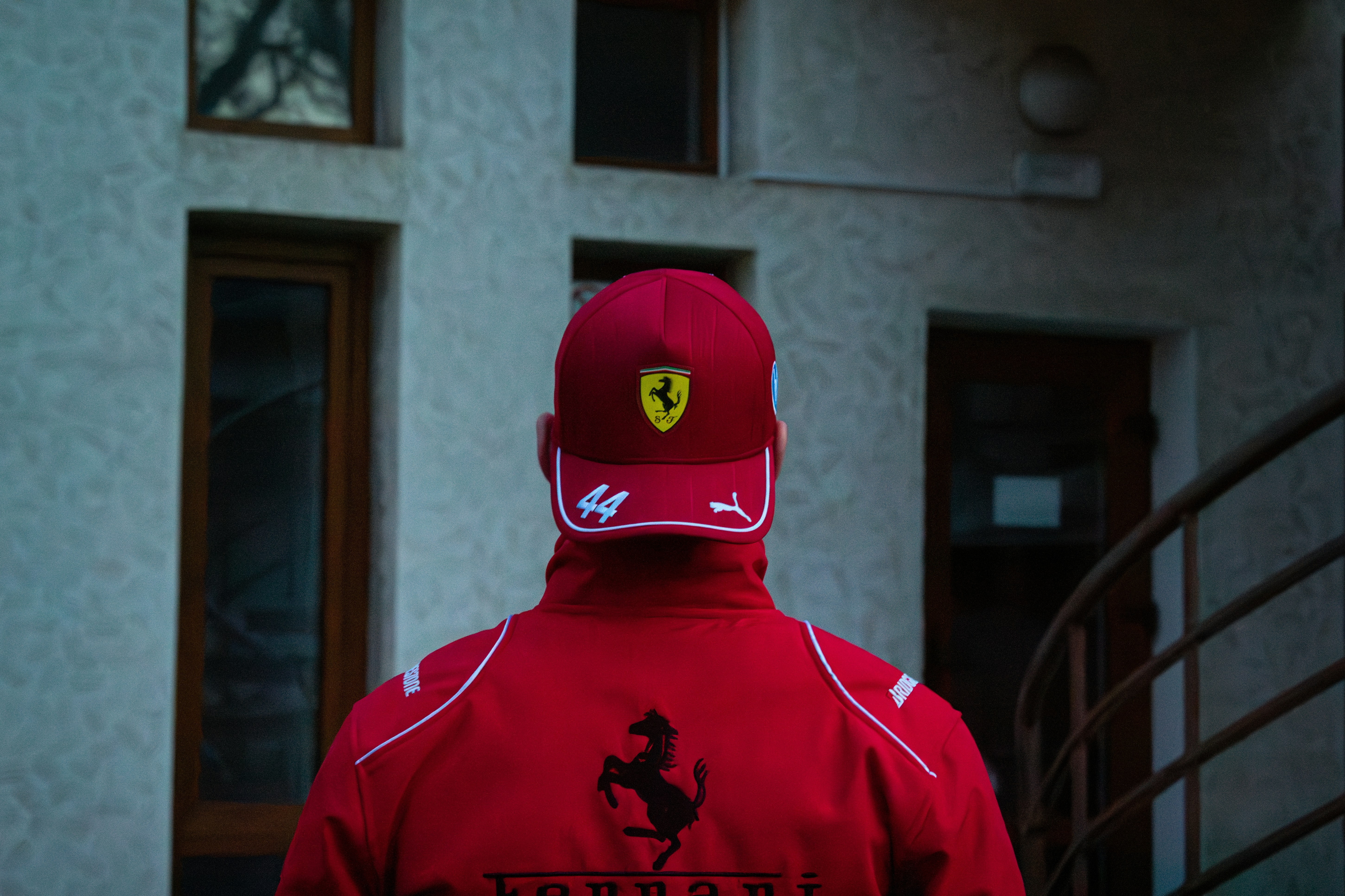 Hombre con una gorra y chaqueta rojas de Ferrari.