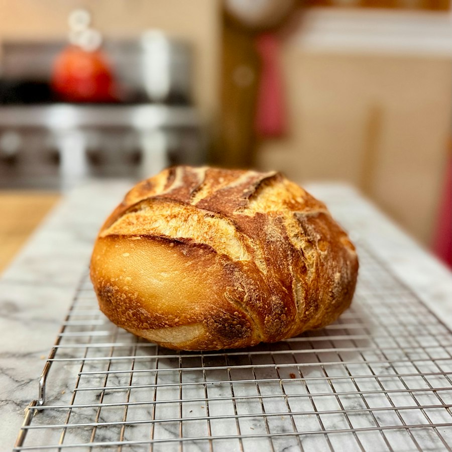 A fresh sourdough loaf cooling on a wire rack