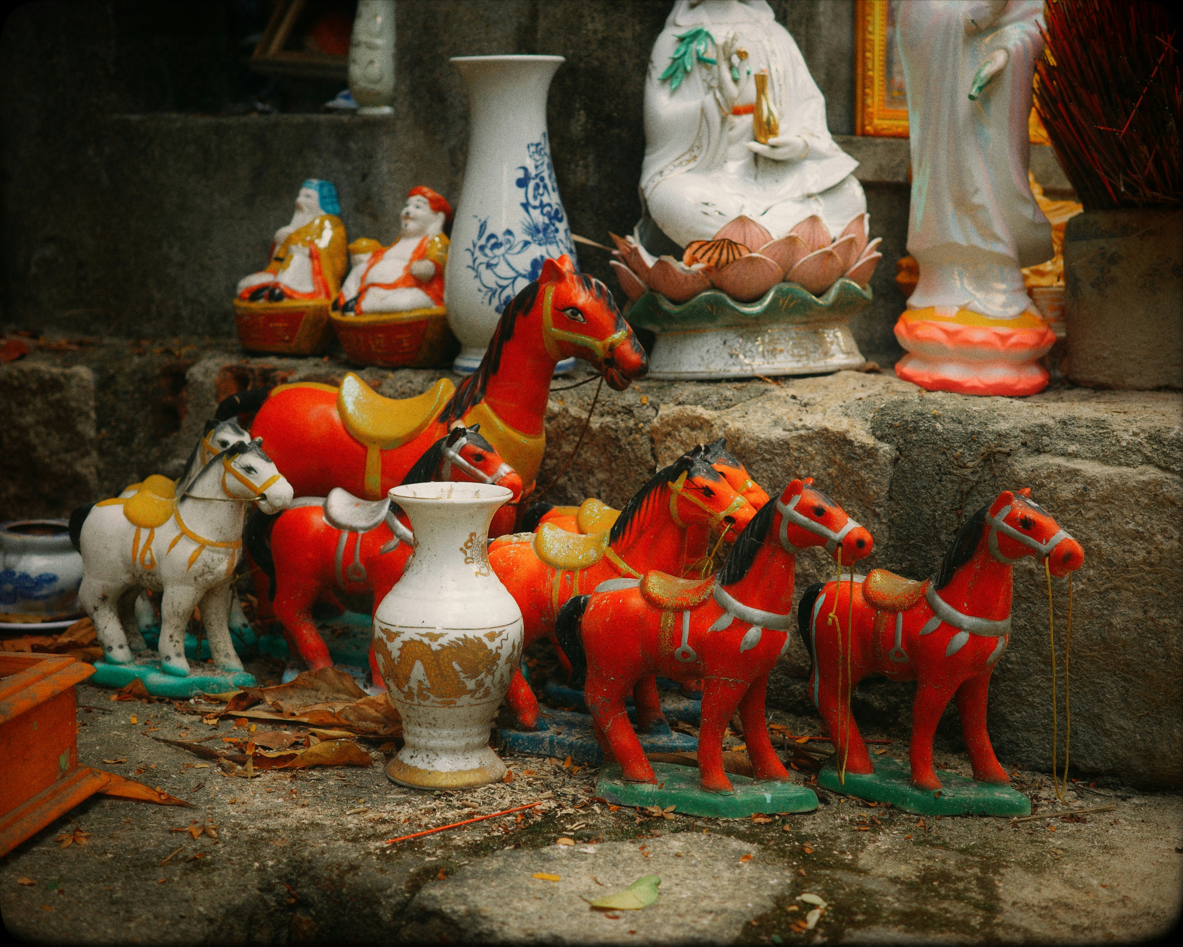 階段に置かれた陶器の馬や壺のコレクション