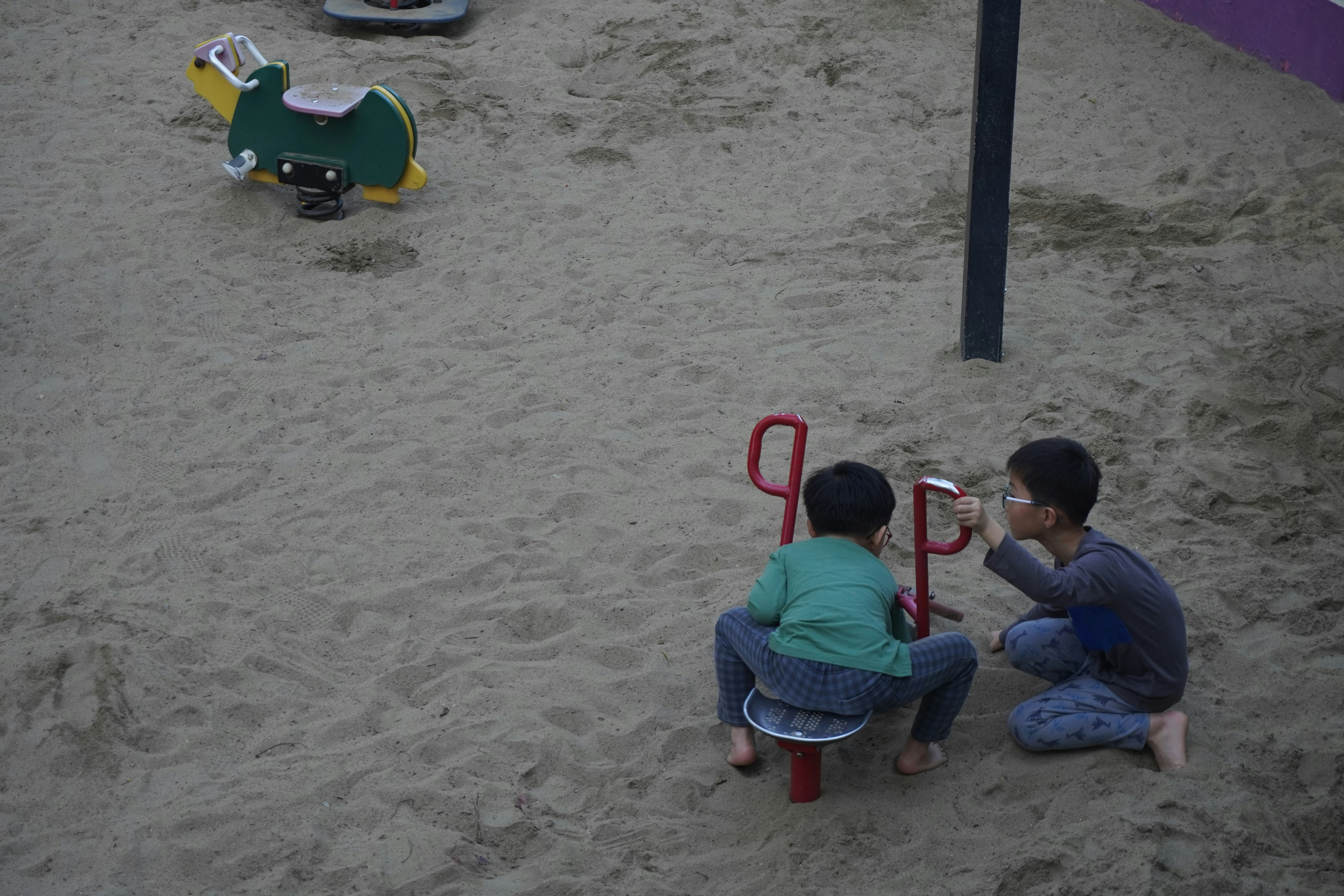 遊び場のシーソーで遊ぶ二人の少年