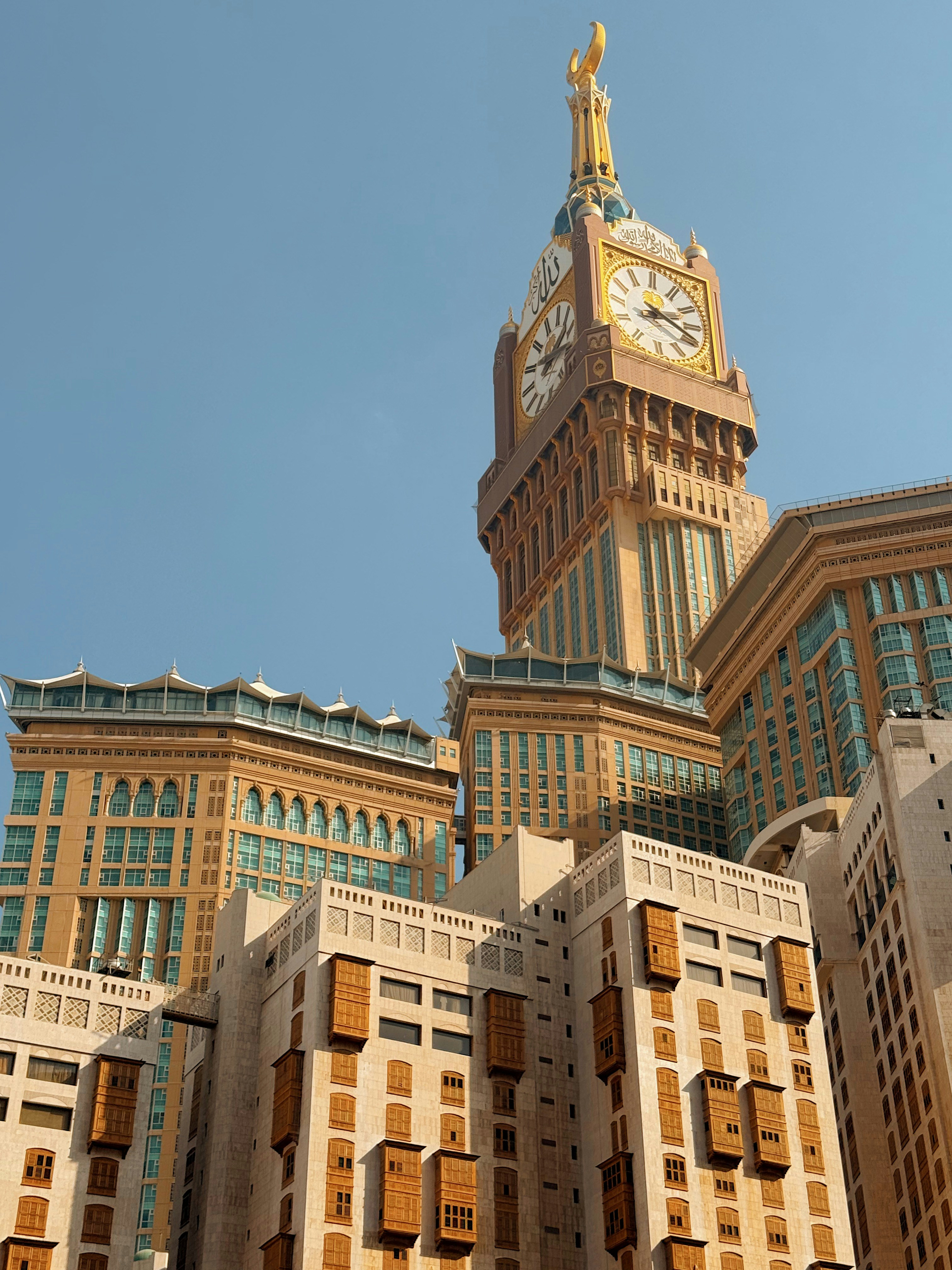 Alto edificio con torre dell'orologio contro un cielo azzurro limpido