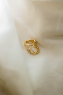Gold earrings with small diamonds on satin fabric