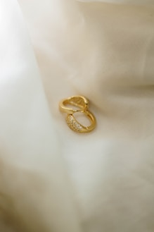 Gold earrings with small diamonds on satin fabric
