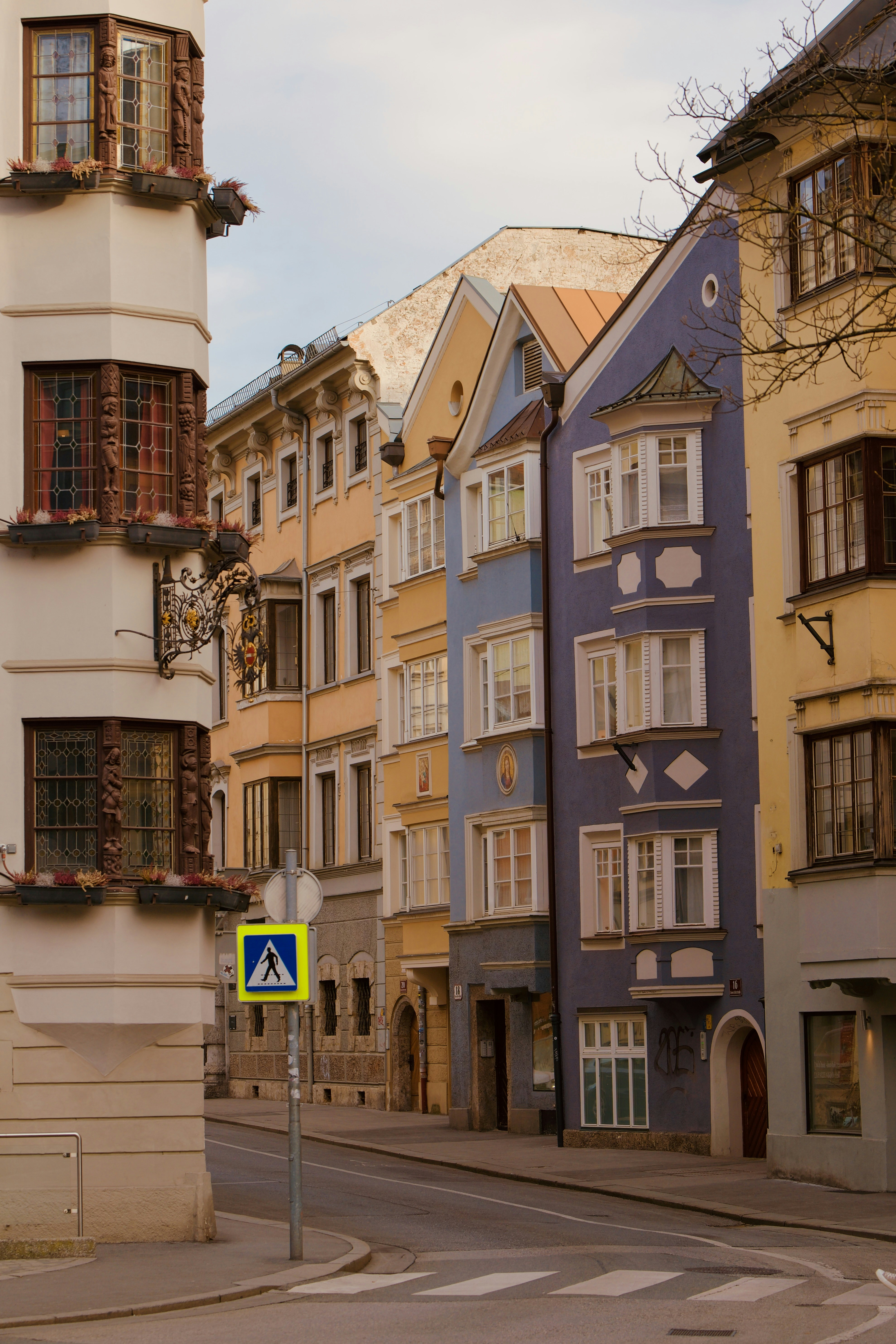 Edificios coloridos bordean una calle europea con paso de peatones.