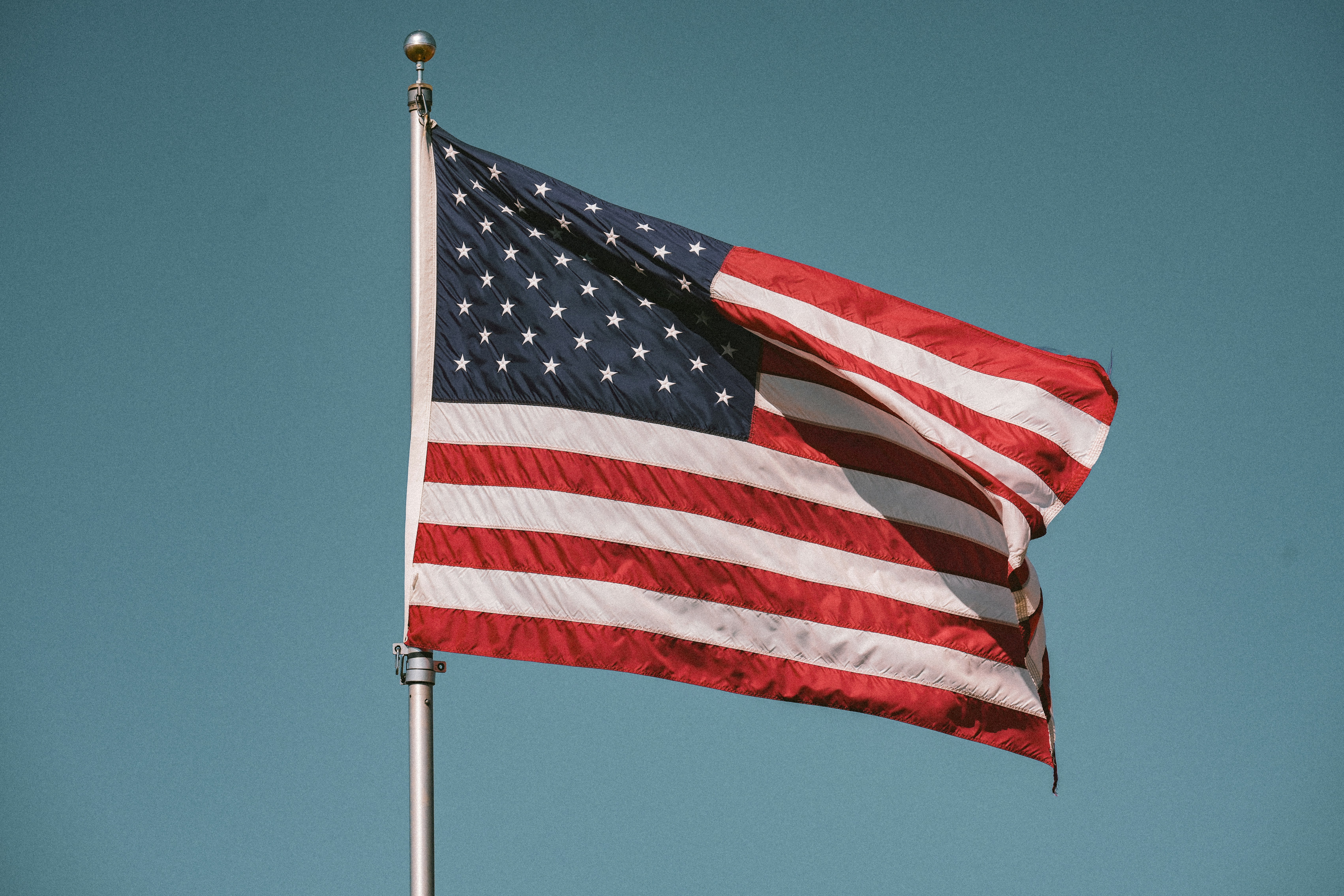 American flag waving against a clear blue sky