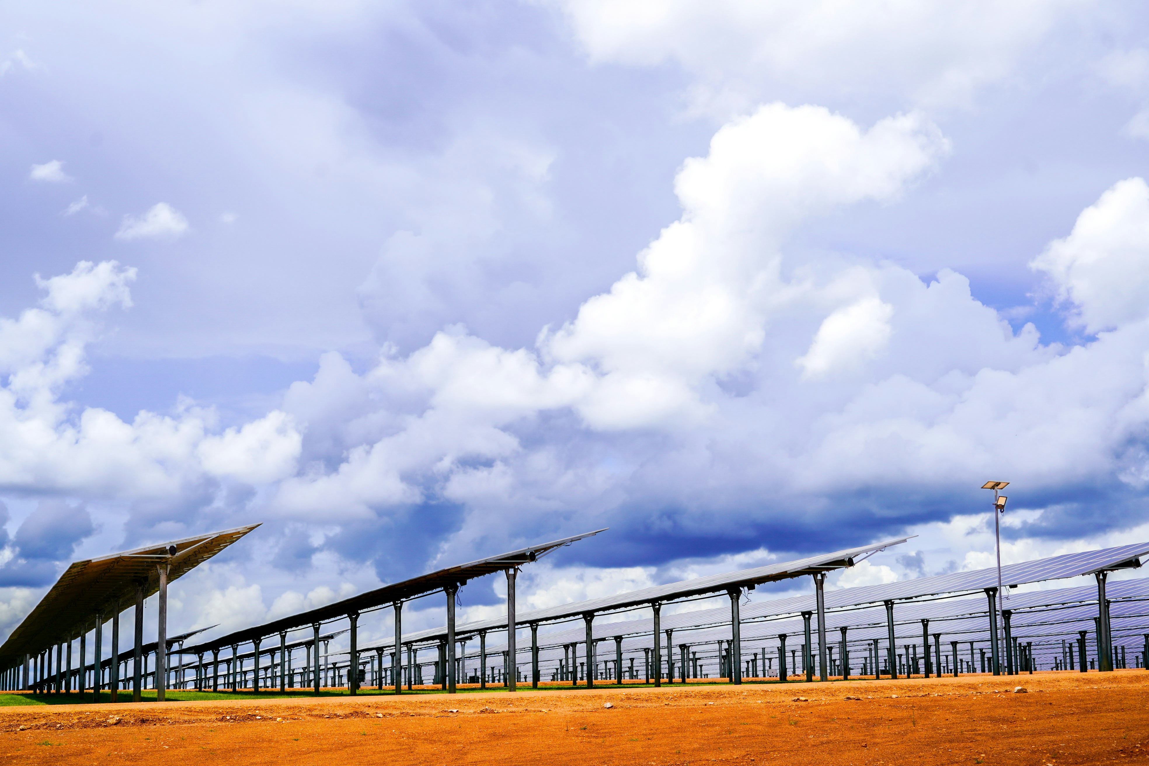 Rows of solar panels under a cloudy sky