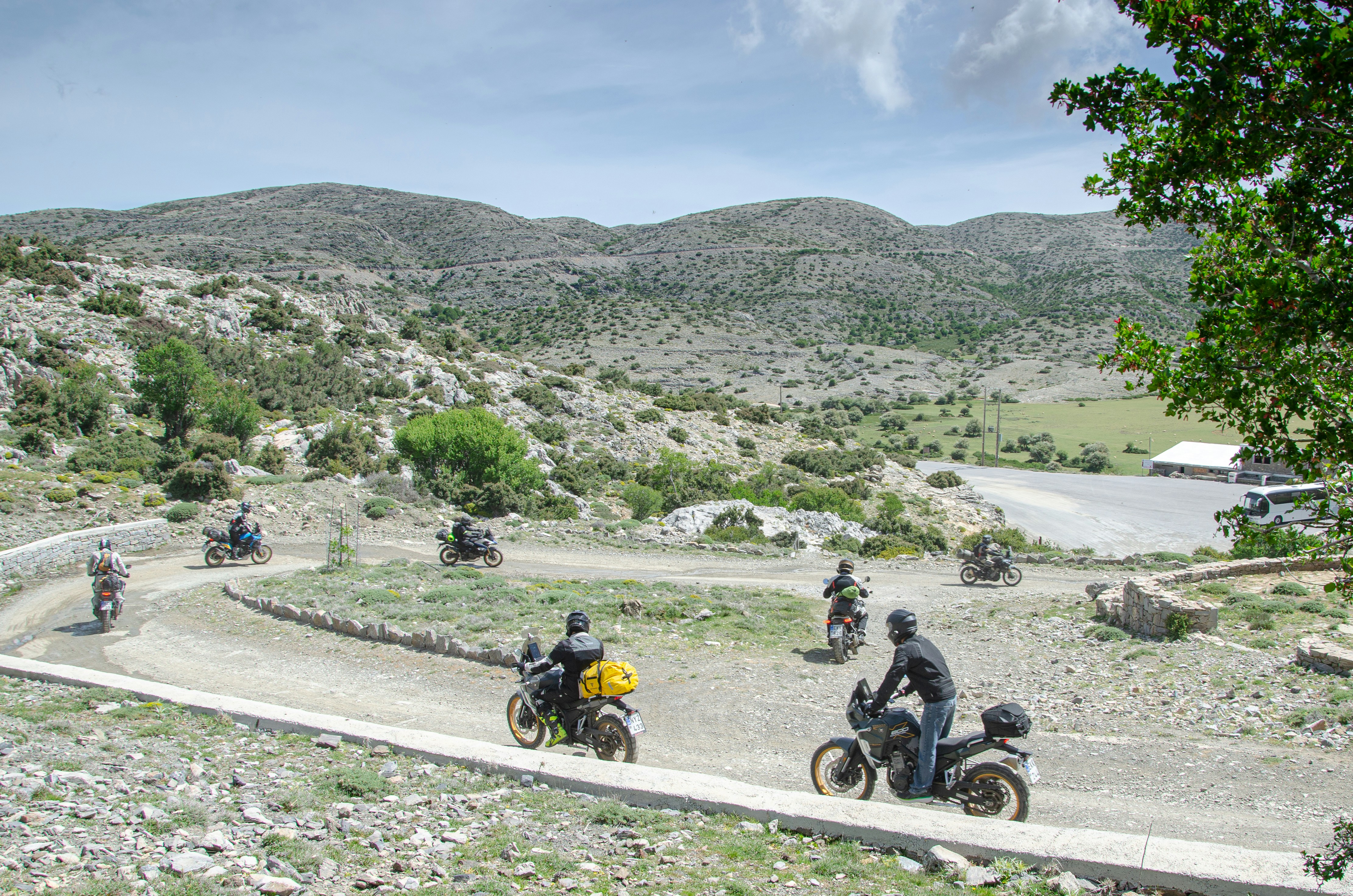 Los motoristas circulan por una carretera de montaña sinuosa.