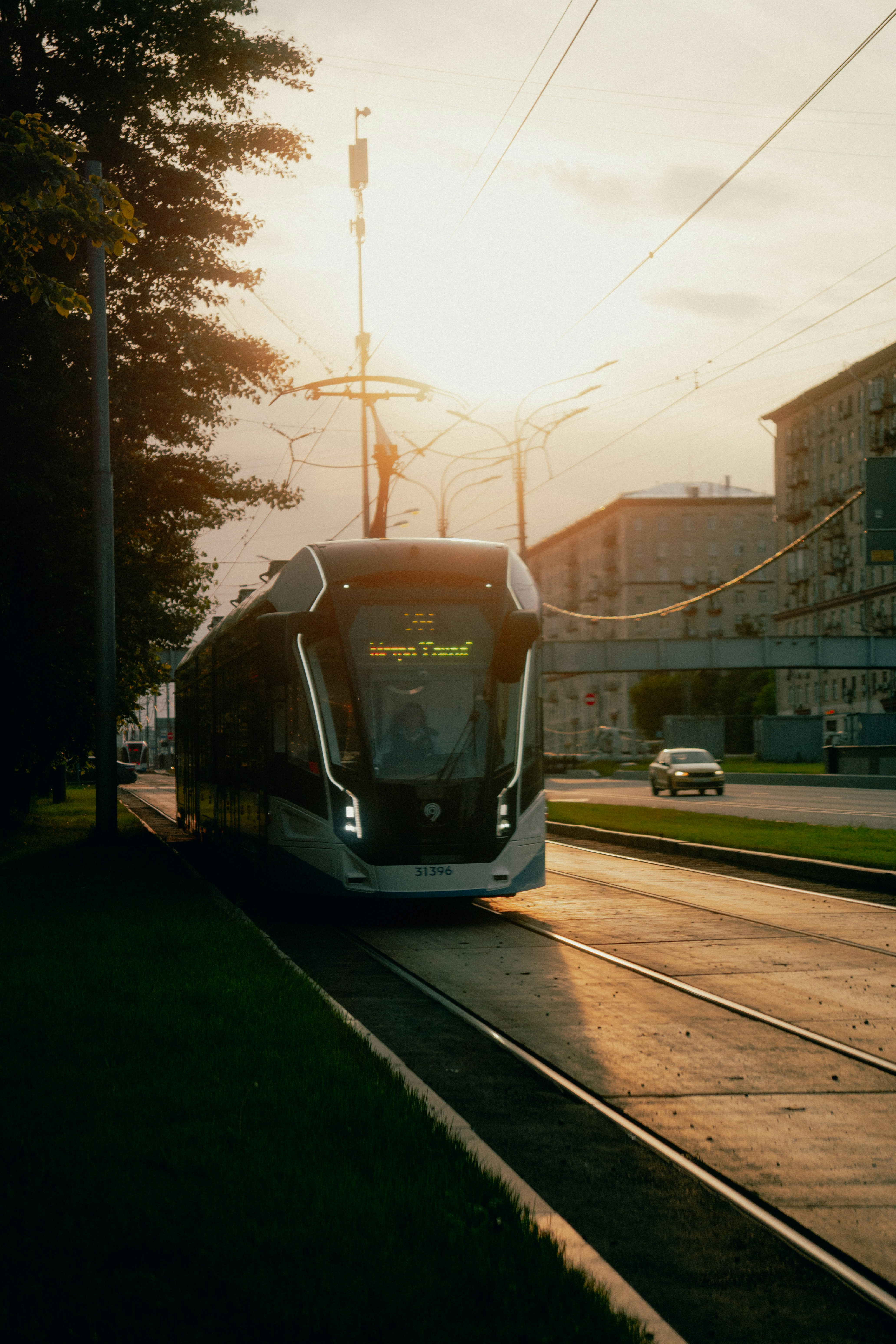 Bonde moderno circulando nos trilhos ao pôr do sol