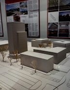 Architectural models of buildings and trees on display.