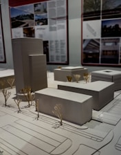 Architectural models of buildings and trees on display.