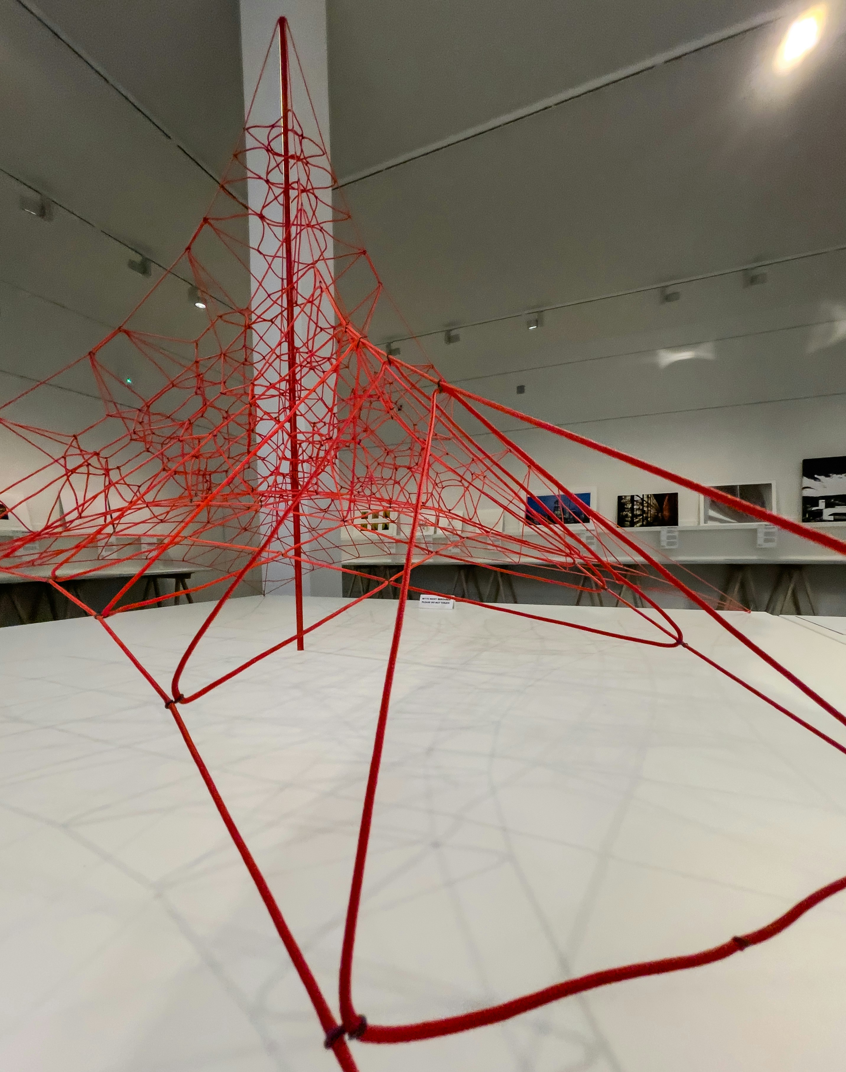 Abstract red wire sculpture in a gallery space