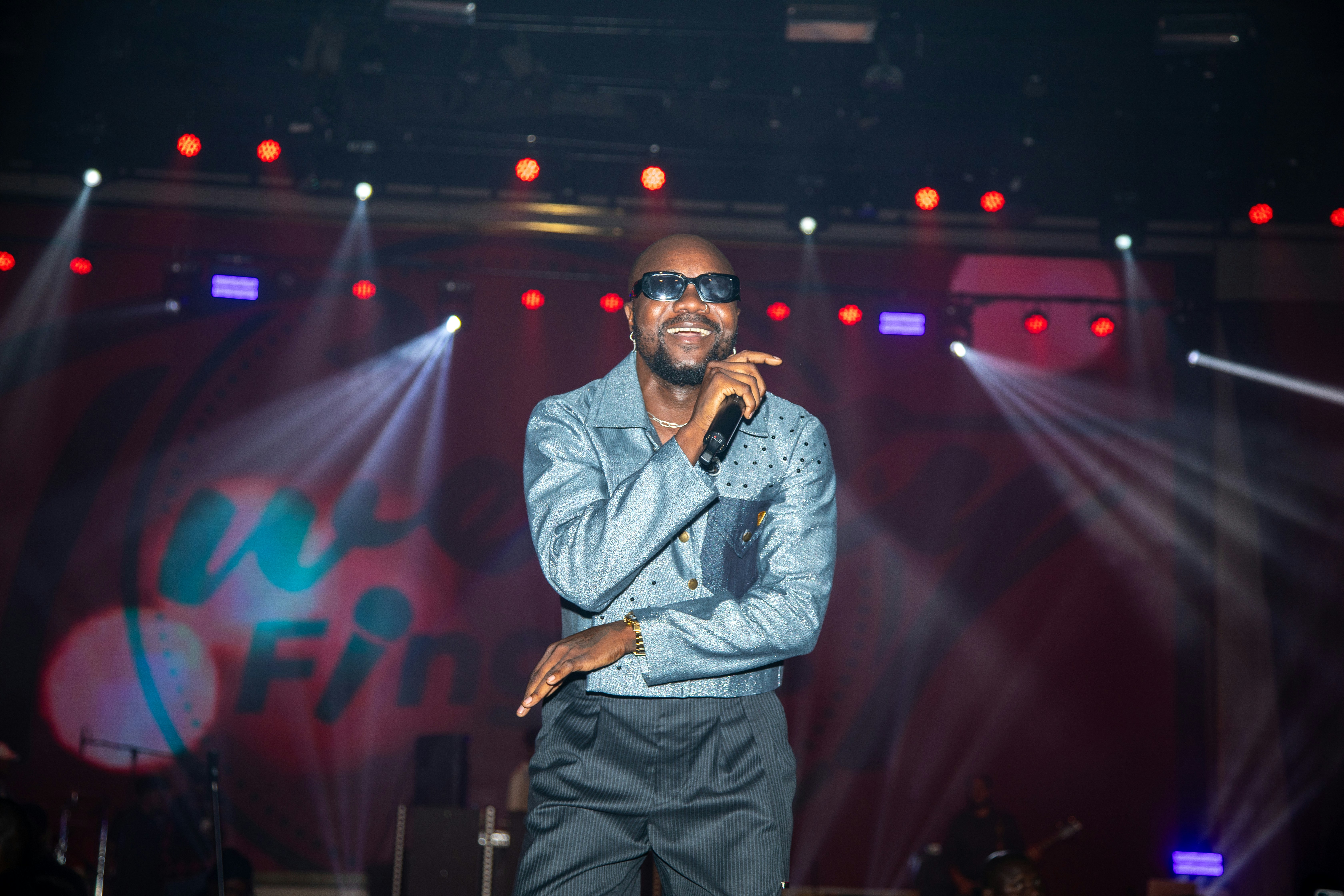 Ein Mann, der auf der Bühne mit Scheinwerfern singt